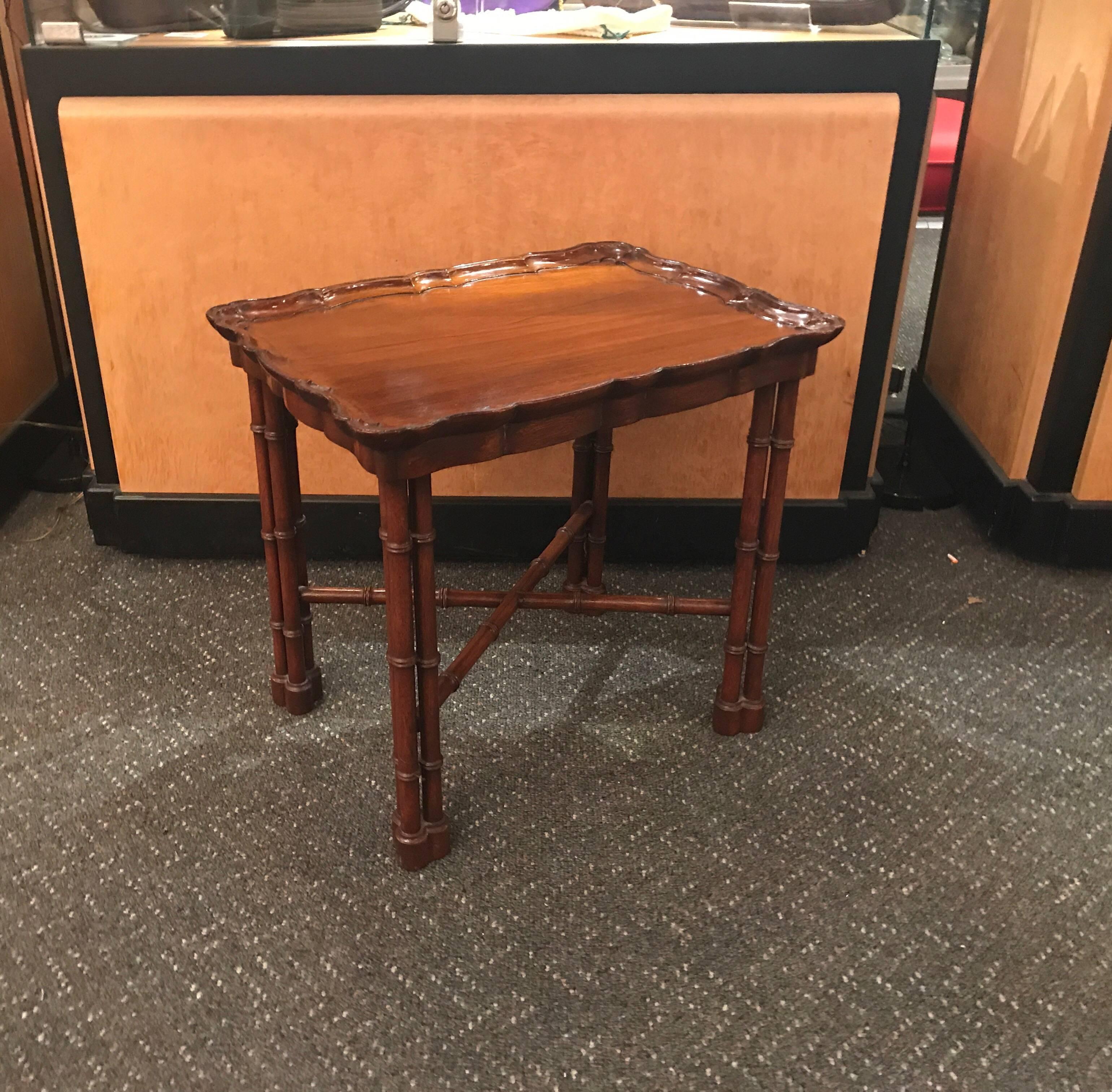 Elegant solid mahogany hand-carved drinks table. The Regency base topped with a well carved piecrust edge. The top is carved from a solid piece of wood. Well made and beautiful. The top is attached.