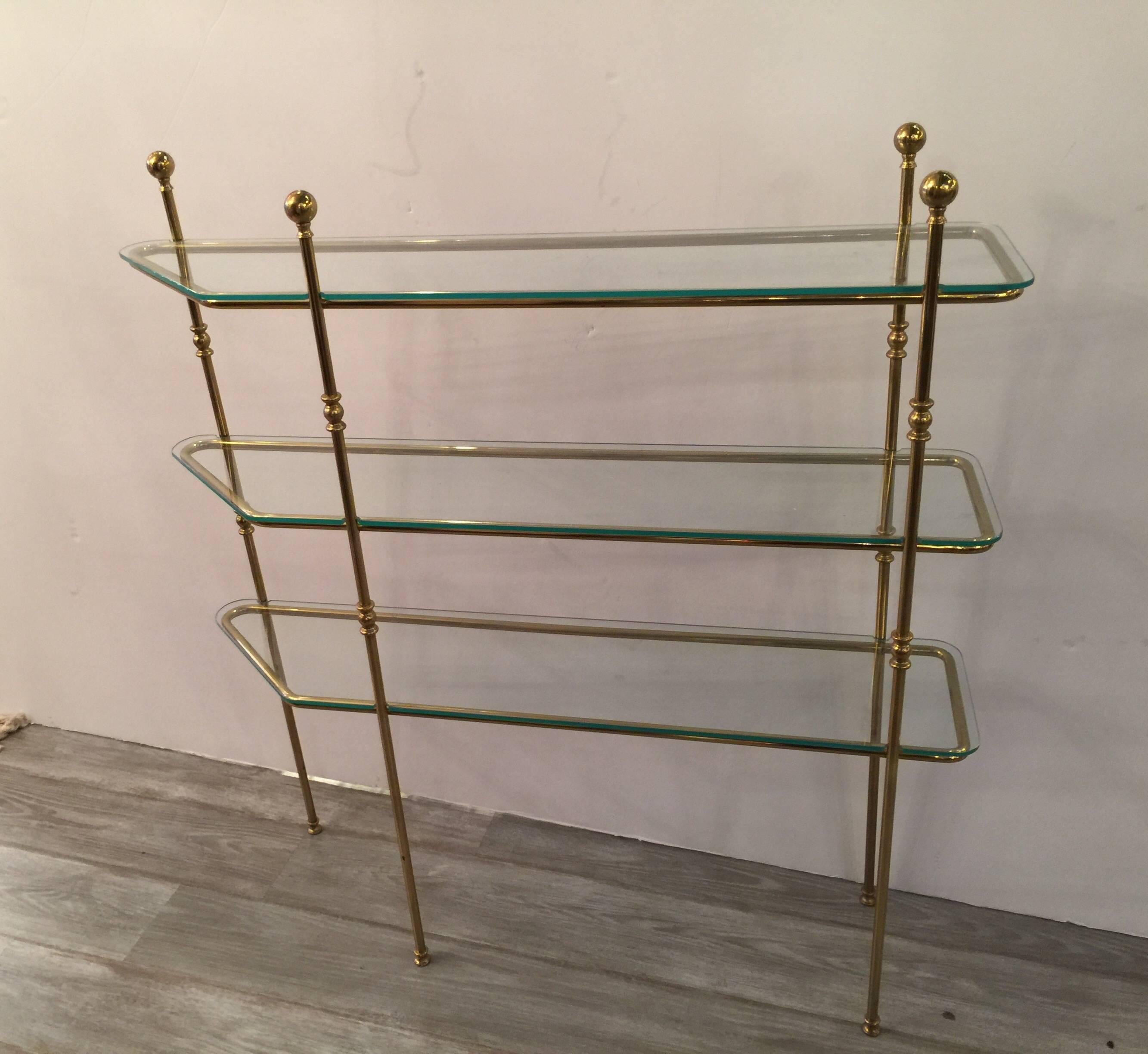 Uniquely shaped Mid-Century Modern brass and glass console etagere . The narrow depth is hard to find along with the angled end on one side and straight end on the other. Perfect for a small area that needs a decorative touch.