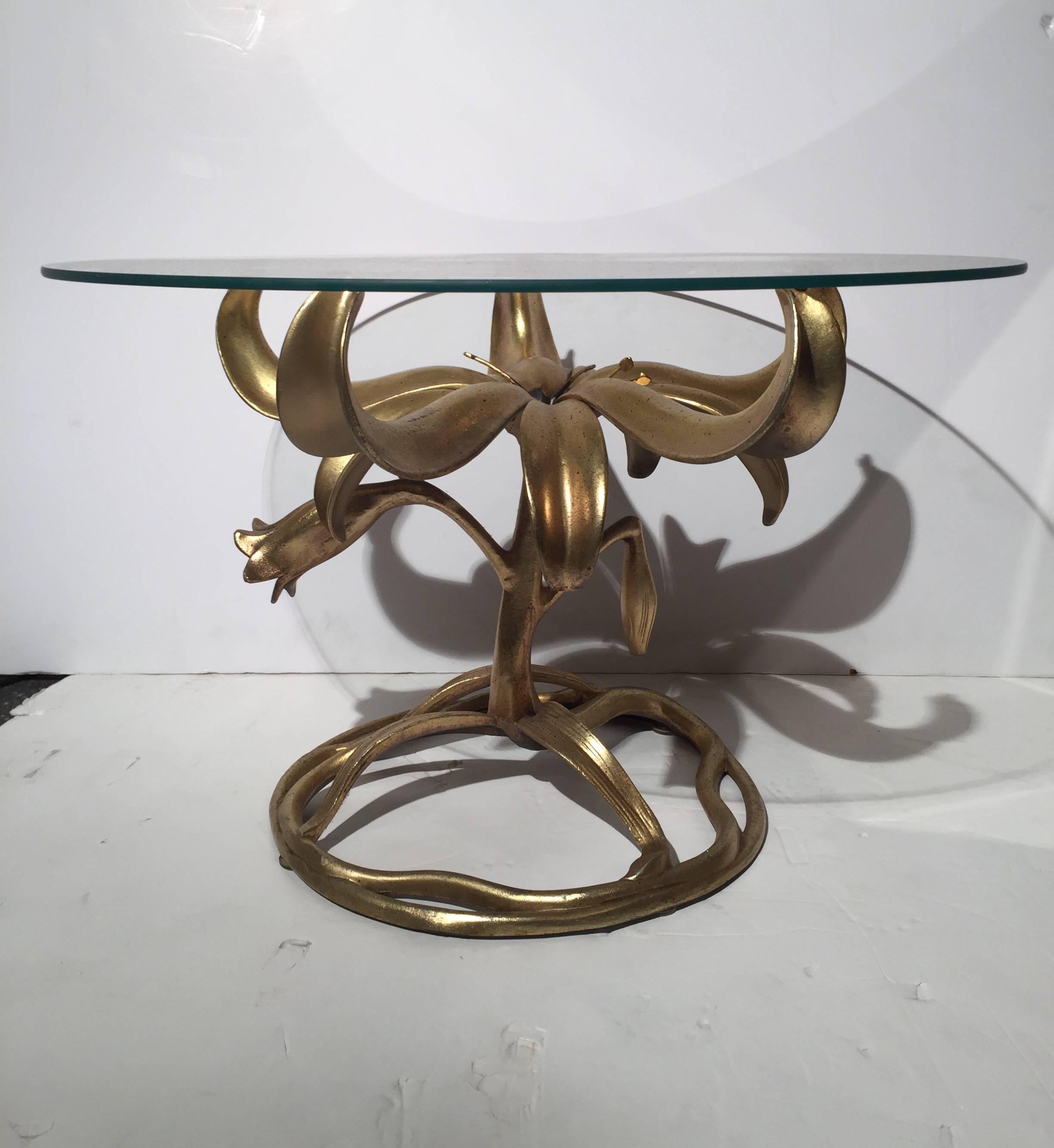 Whimsical gilded lily decorator side table by Arthur Court. The beautifully sculpted base with glass top.