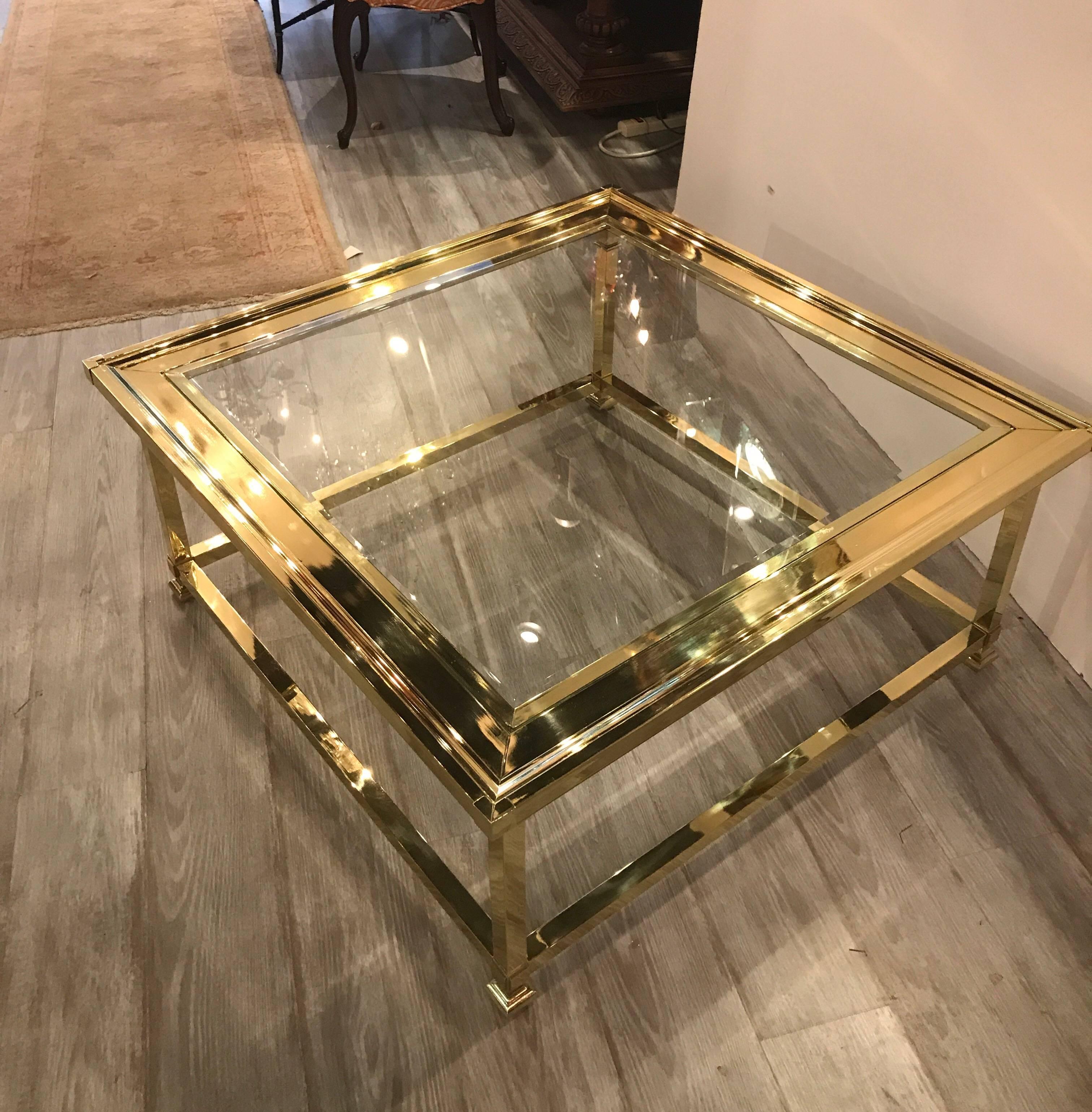 High style bevelled glass and polished brass cocktail table by Mastercraft. The sturdy polished brass base with original bevelled glass top. A rare and hard to find large size.