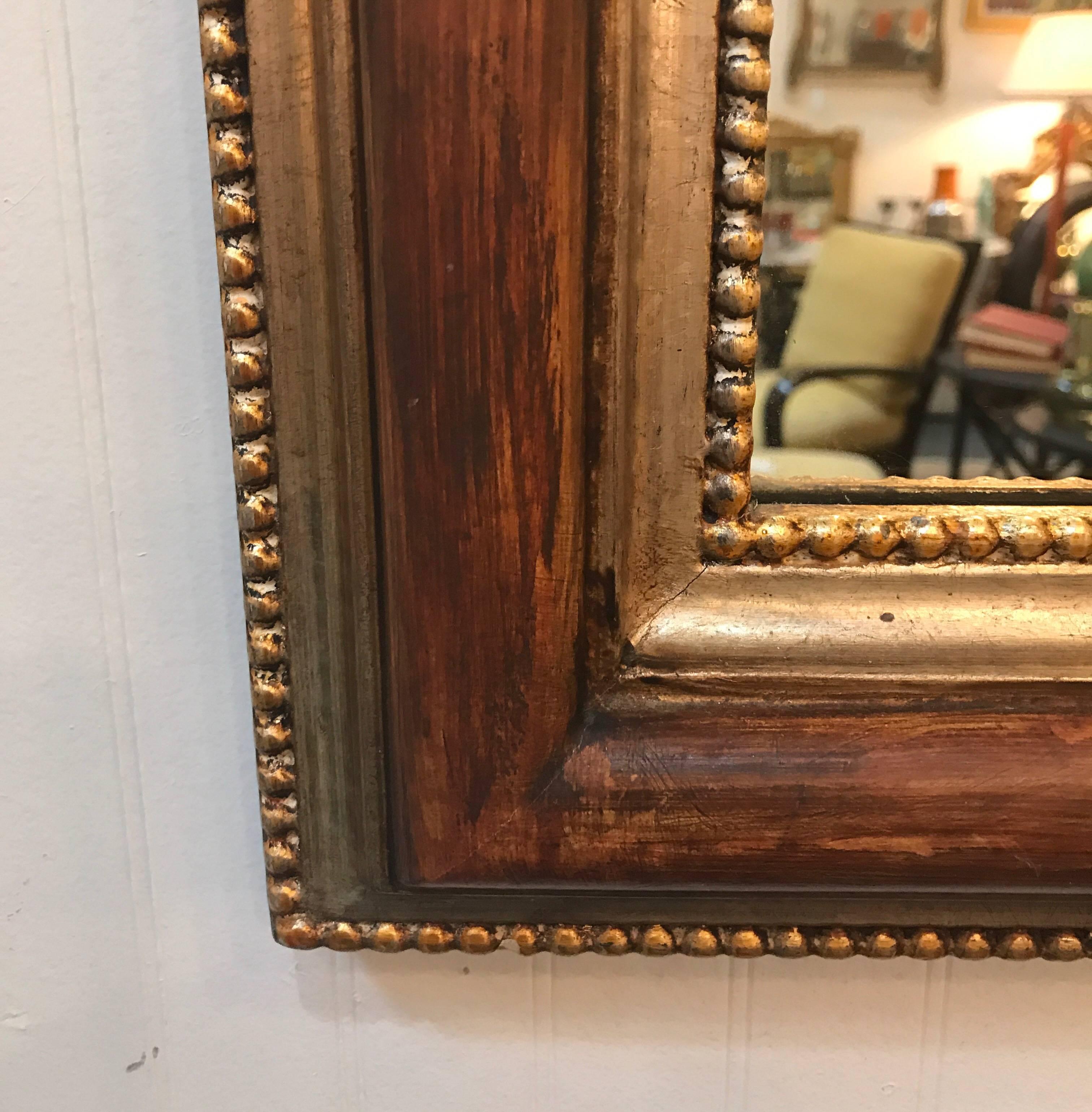 A Louis Philippe arched top mirror by LaBarge. The painted wood finish with gilt bands and beading on the inside and outside.