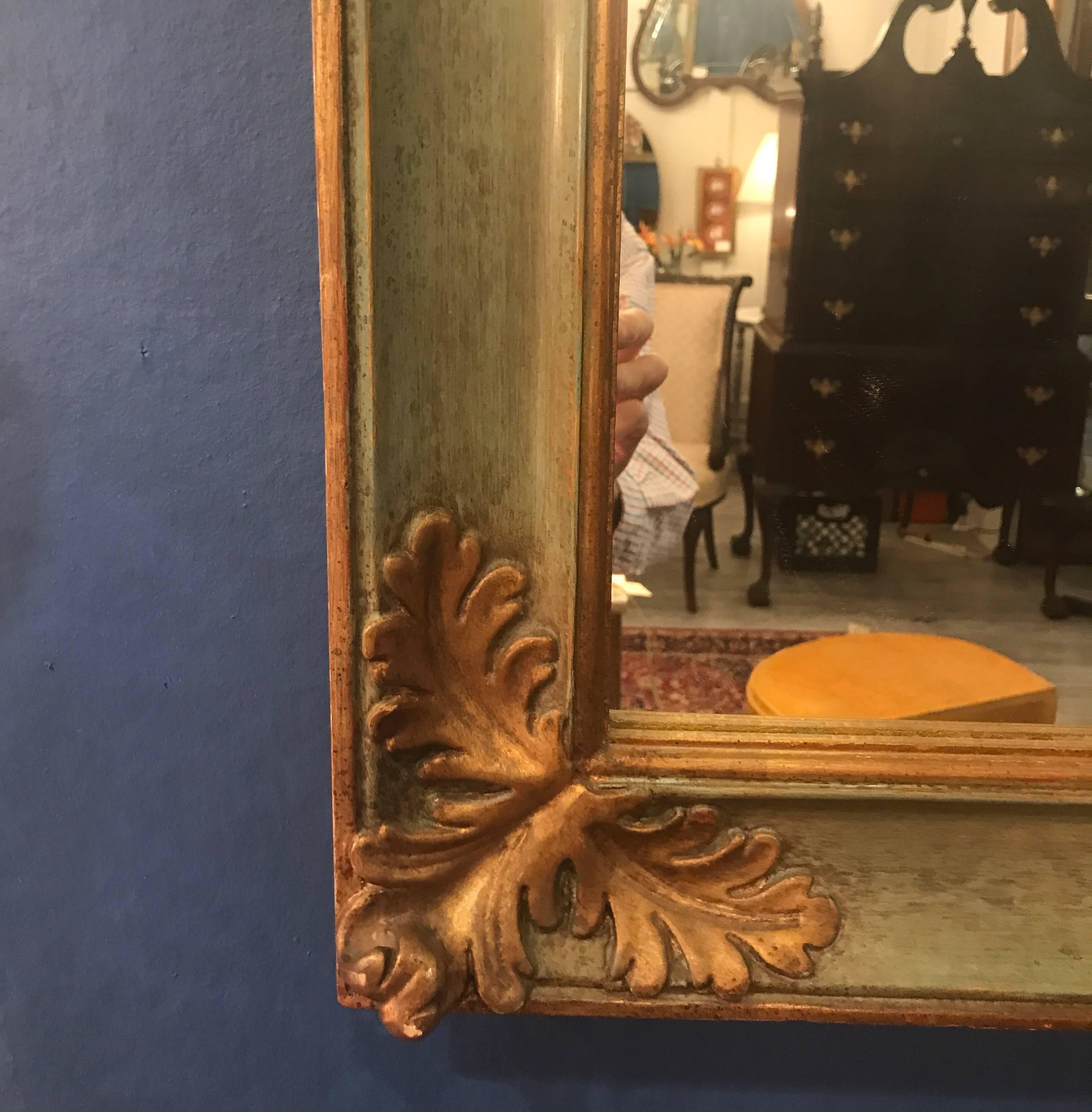 Elegant parcel giltwood Italian mirror. The sage green painted background with gilt edges and other detailing all around the frame.