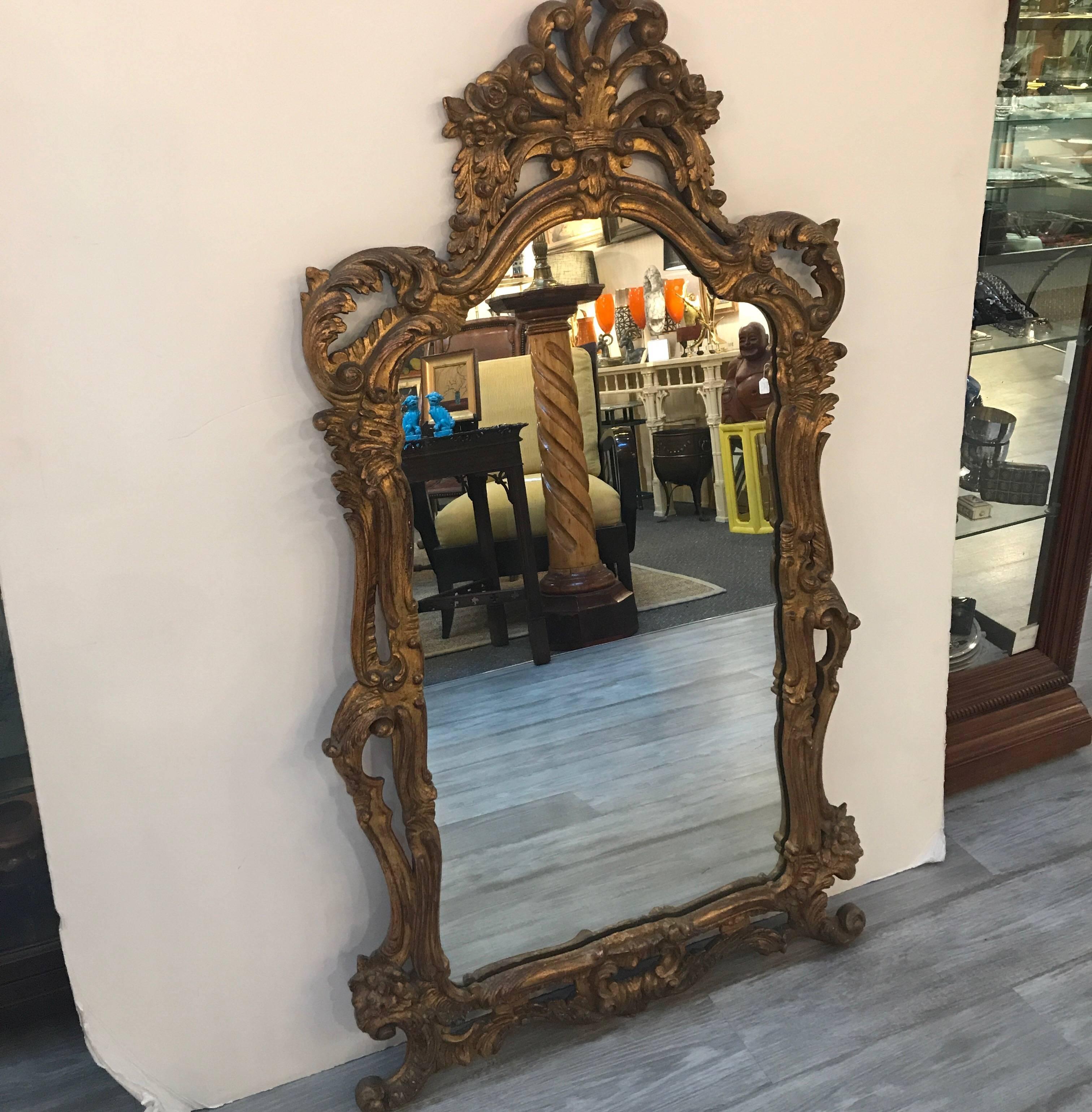 Heavily carved Rococo style French giltwood mirror. The pierced plume top with carved sides and bottom. The silvering on the mirror is very clear.