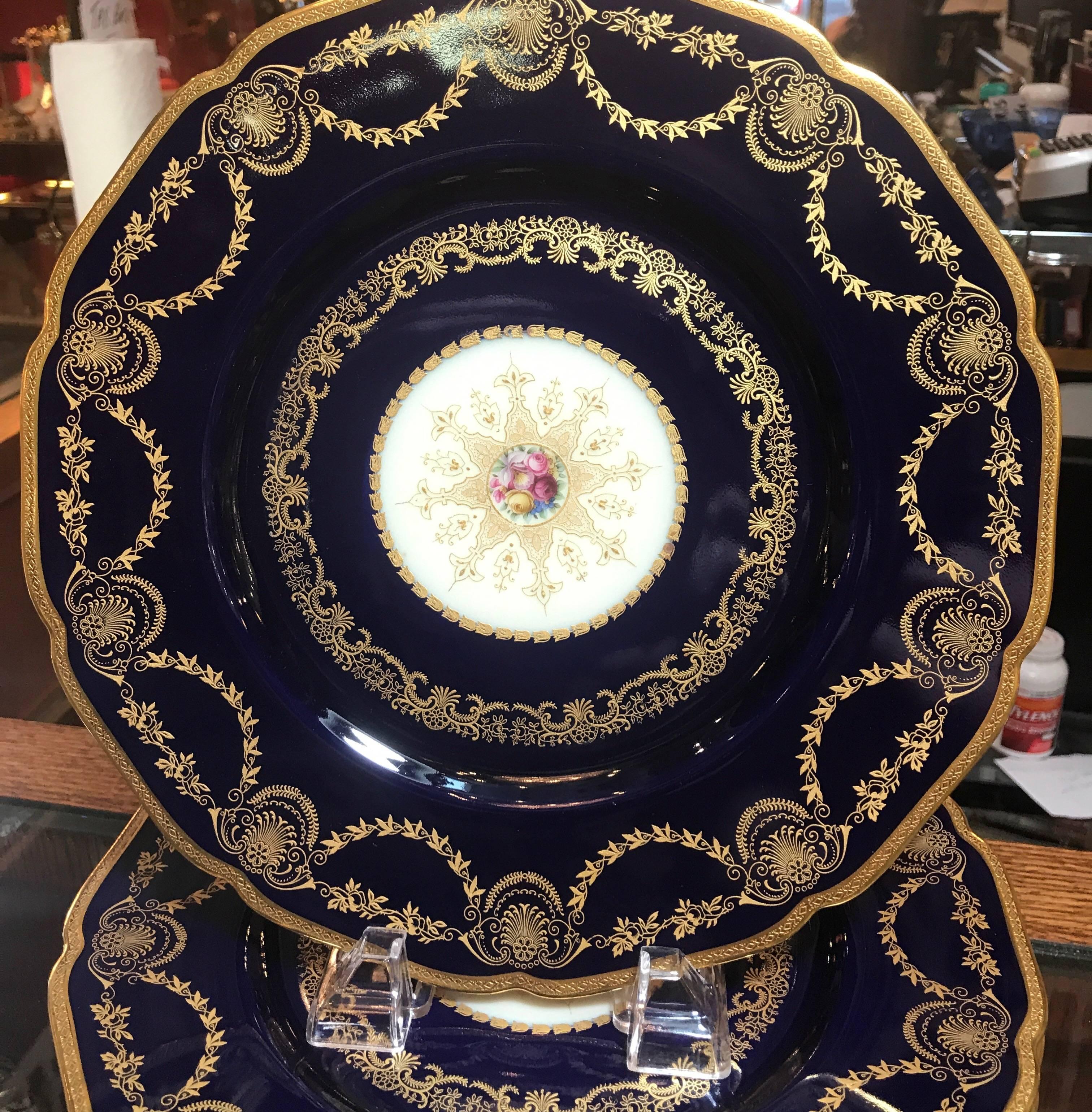 Elegant and opulent deep cobalt blue service plates. The rich borders with gilt swags and borders with a center gilt medallion with Dresden floral cartouch. Grace and style from the gilded age, early 20th century.