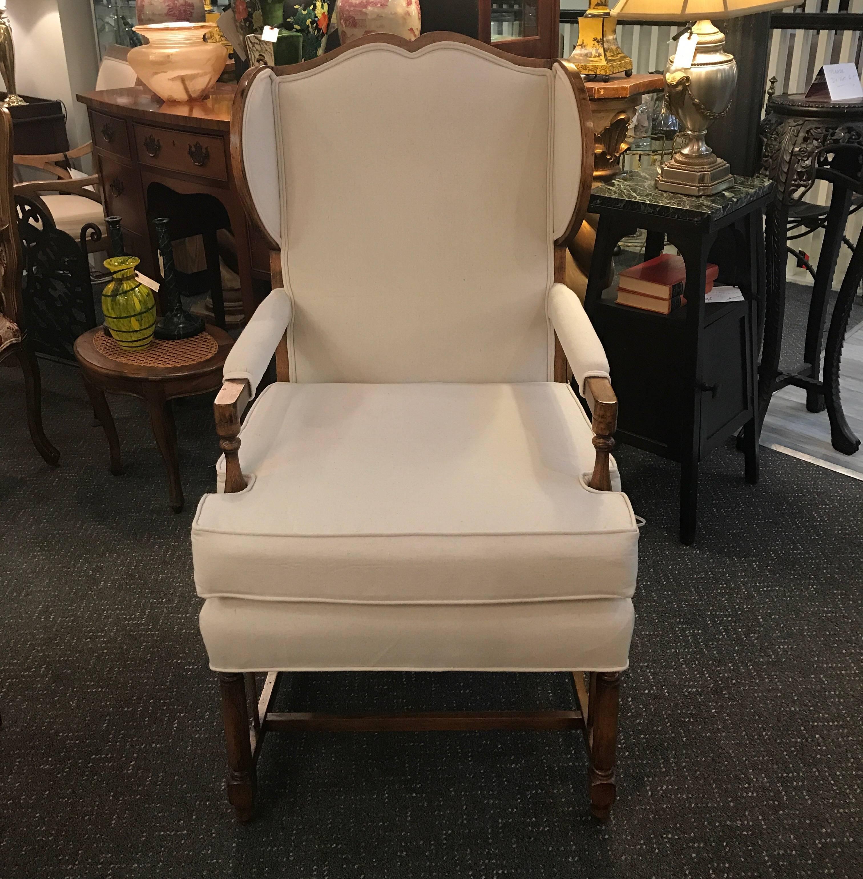 Charming open arm wing chair with a complimenting ottoman. The warm casual style in natural cotton linen. The frame with the wings on the chair having wood on the outside. The ottoman frame is a complimenting color but the leg is different from the