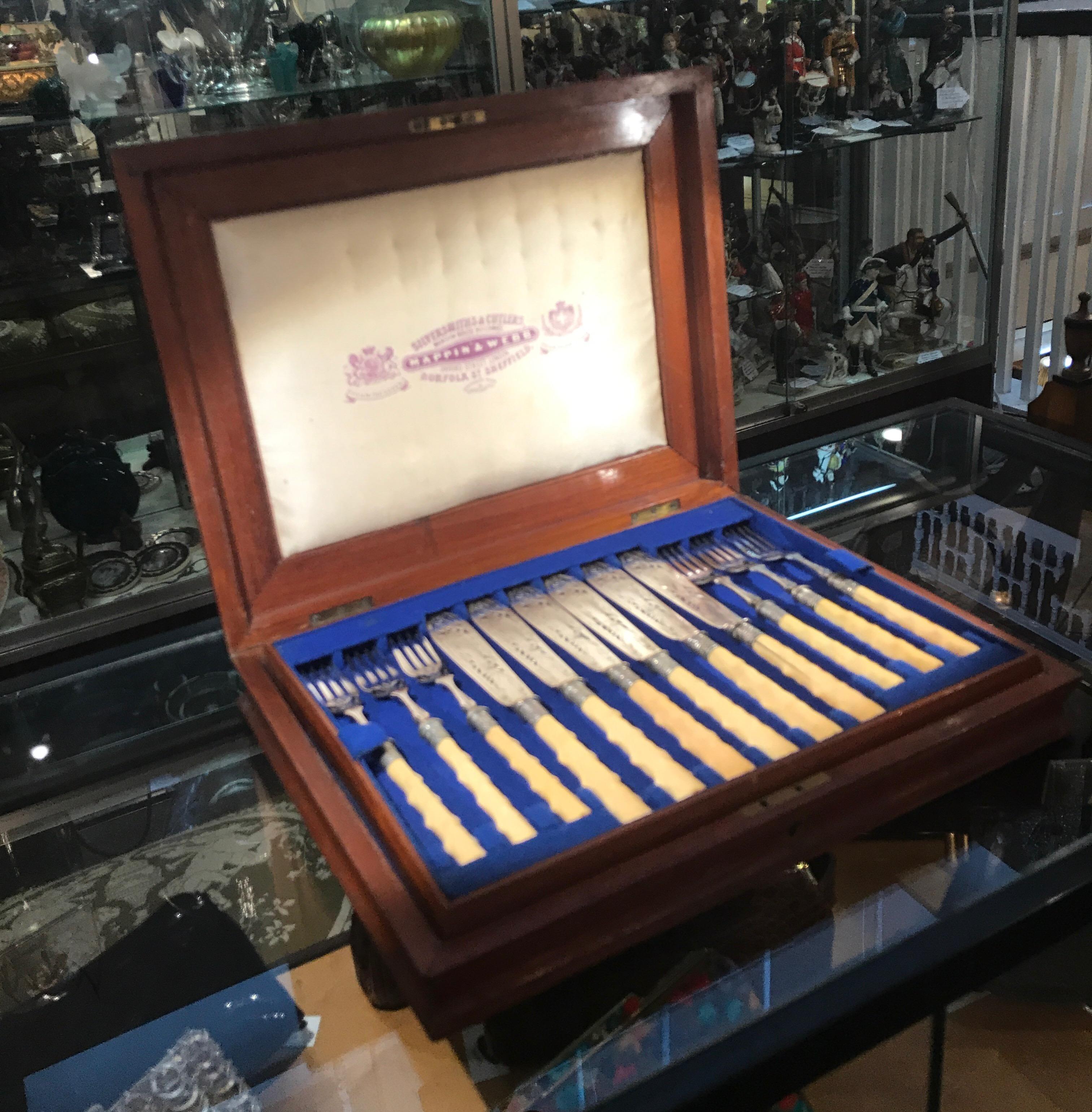 Elegant service for 12 fish set by Mappin & Webb, London. The set has two trays with 6 knives and 6 forks for a total of 12 knives and forks. The carved bone twig handles with intricately engraved silver plate blades and forks. The knives with