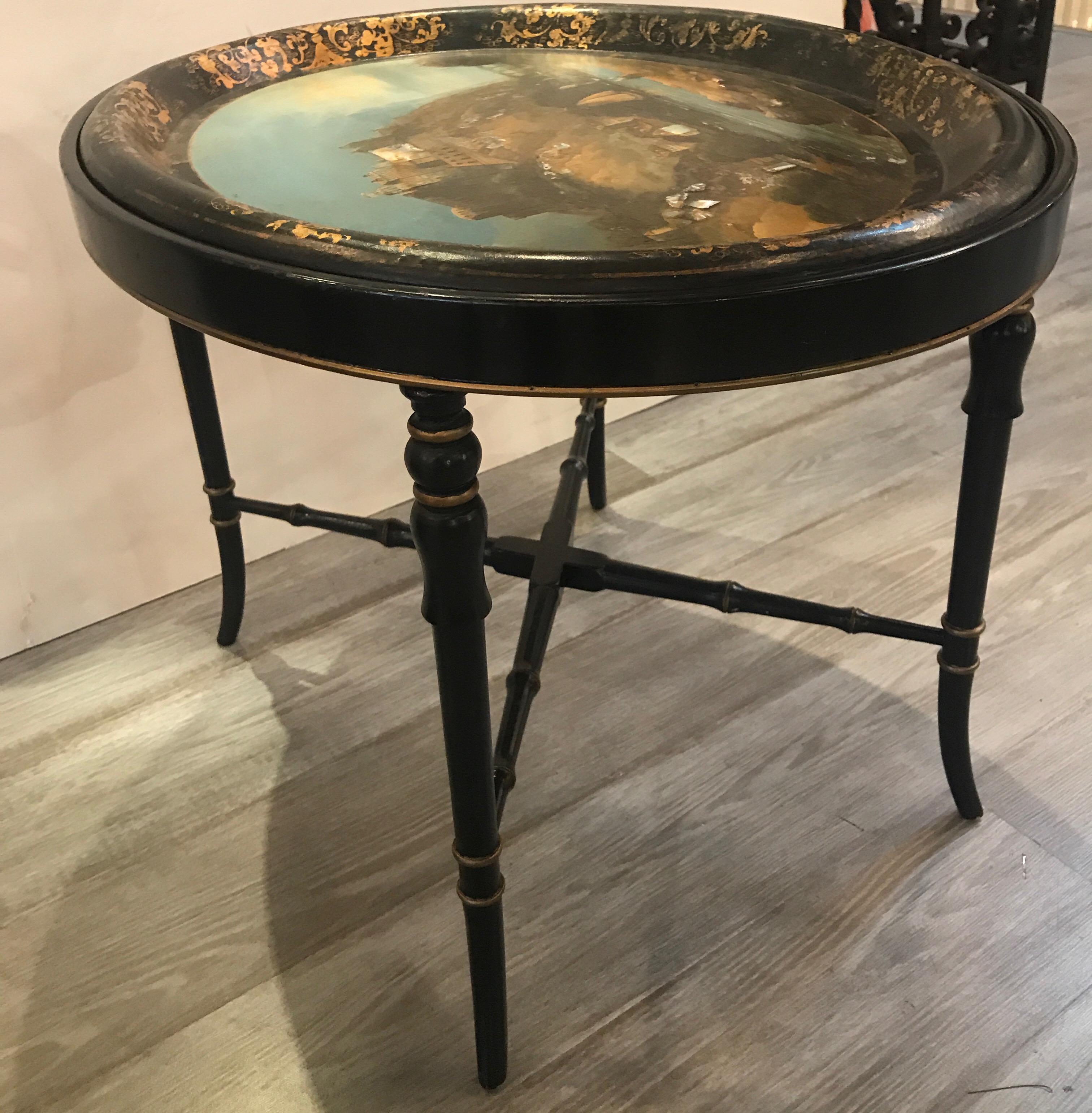 Fabulous English hand painted papier mâché tray table with ebonized regency style base. The hand painted bucolic scene with hand gilt border, circa mid-19th century with a later custom base. Diminutive size of 26 inches wide by 20.5 inches deep.