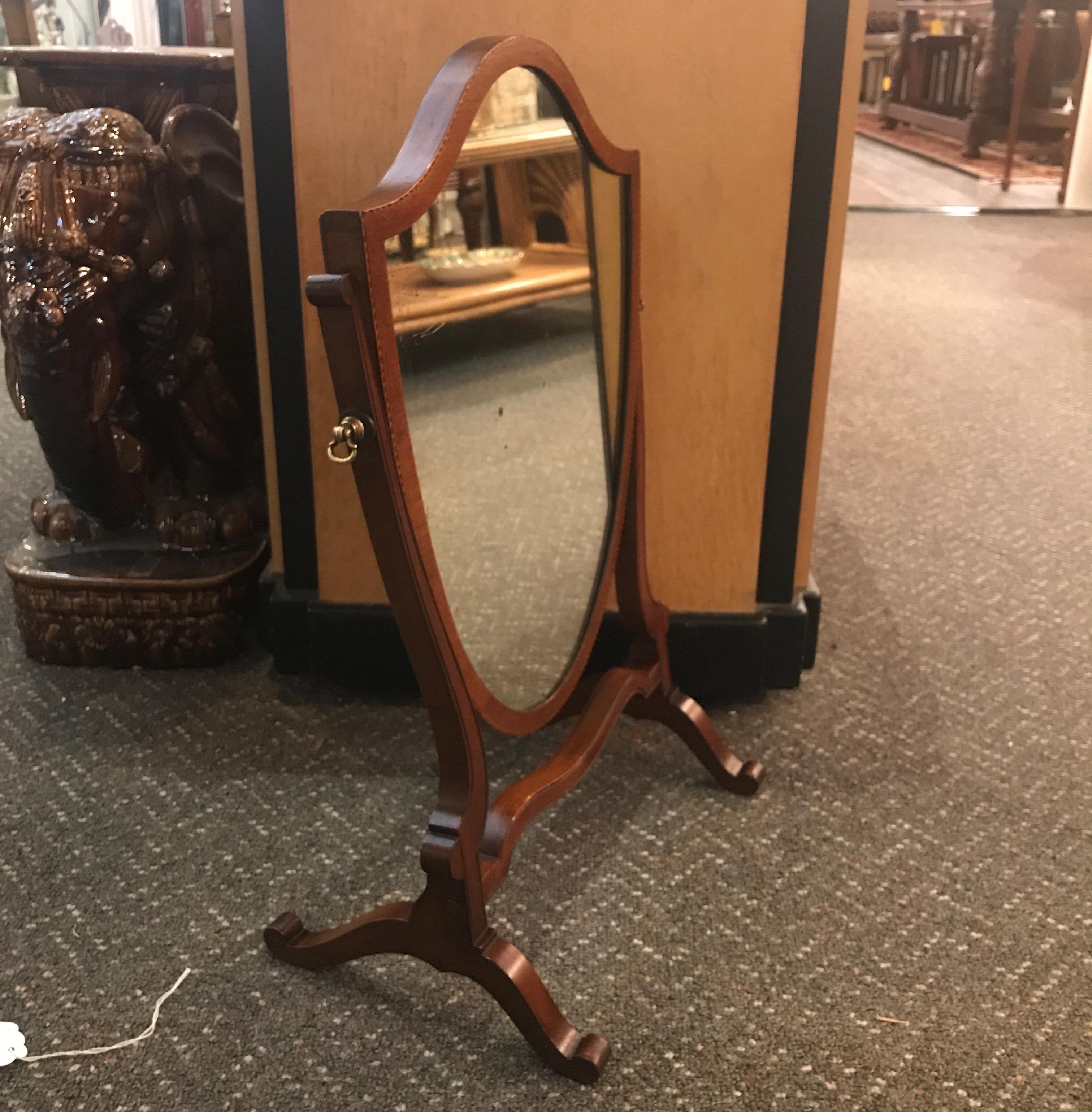 Graceful Hepplewhite shield dressing mirror on Stand. The mahogany mirror with satinwood and ebony inlaid edge. Late 19th century with original mirror showing some silver fade and small spots.  Ask for a shipping quote using Fedex or UPS, the