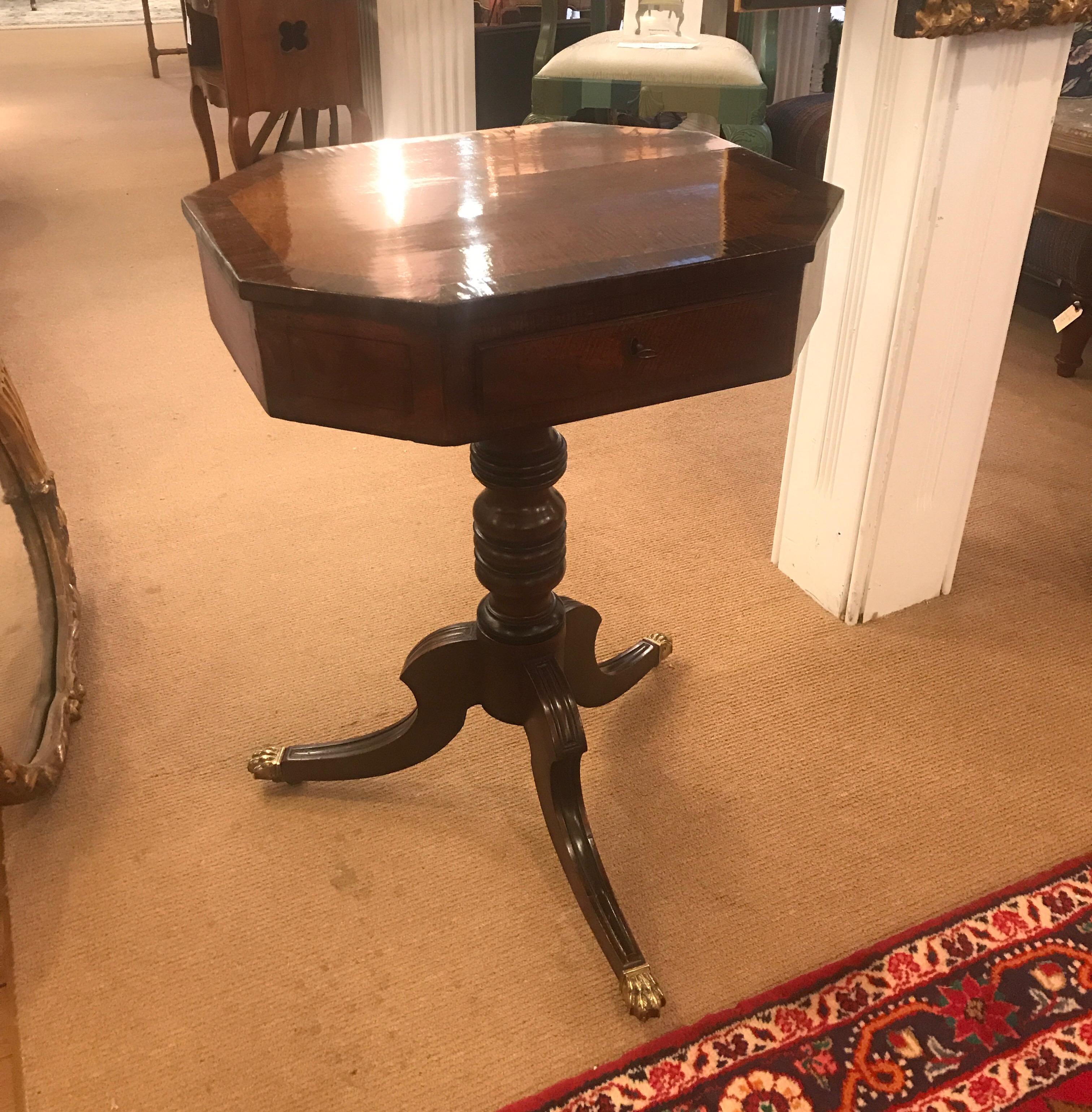English Regency period accent table with small drawer. The top with pencil ebony inlay with thick apron concealing a center drawer resting on a central column and tripod base. High quality early 19th century England.