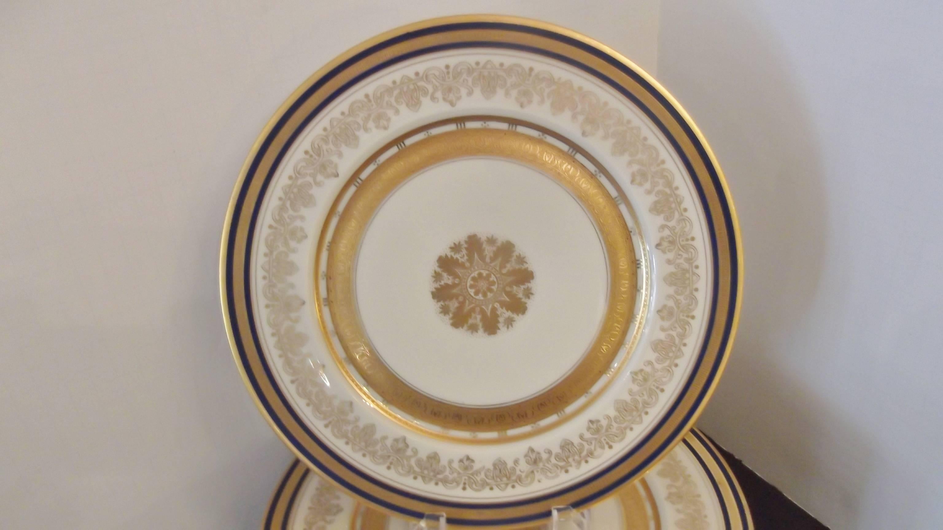 Lovely cobalt banded service plates with gilt borders and center medallion, circa 1920 made by Heinrich & Company, retailed by Ovington Brothers New York, 5th Avenue. Set a beautiful table or display a gorgeous cabinet with a full set of 12. One
