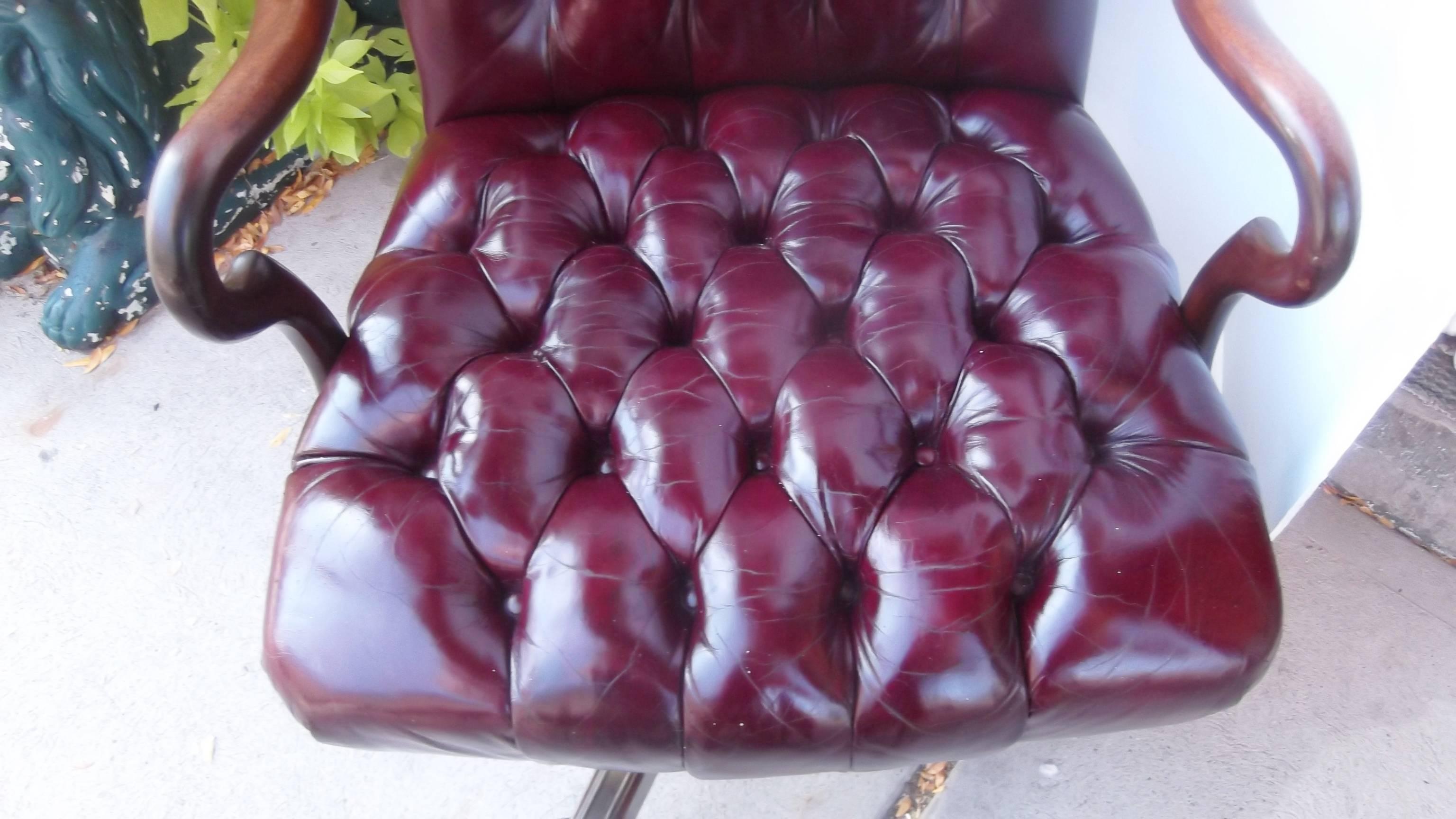 Cordovan leather chair with mahogany goose neck arms.
Biscuit tufted back and seat, resting on mahogany swivel base.
All leather front to back.