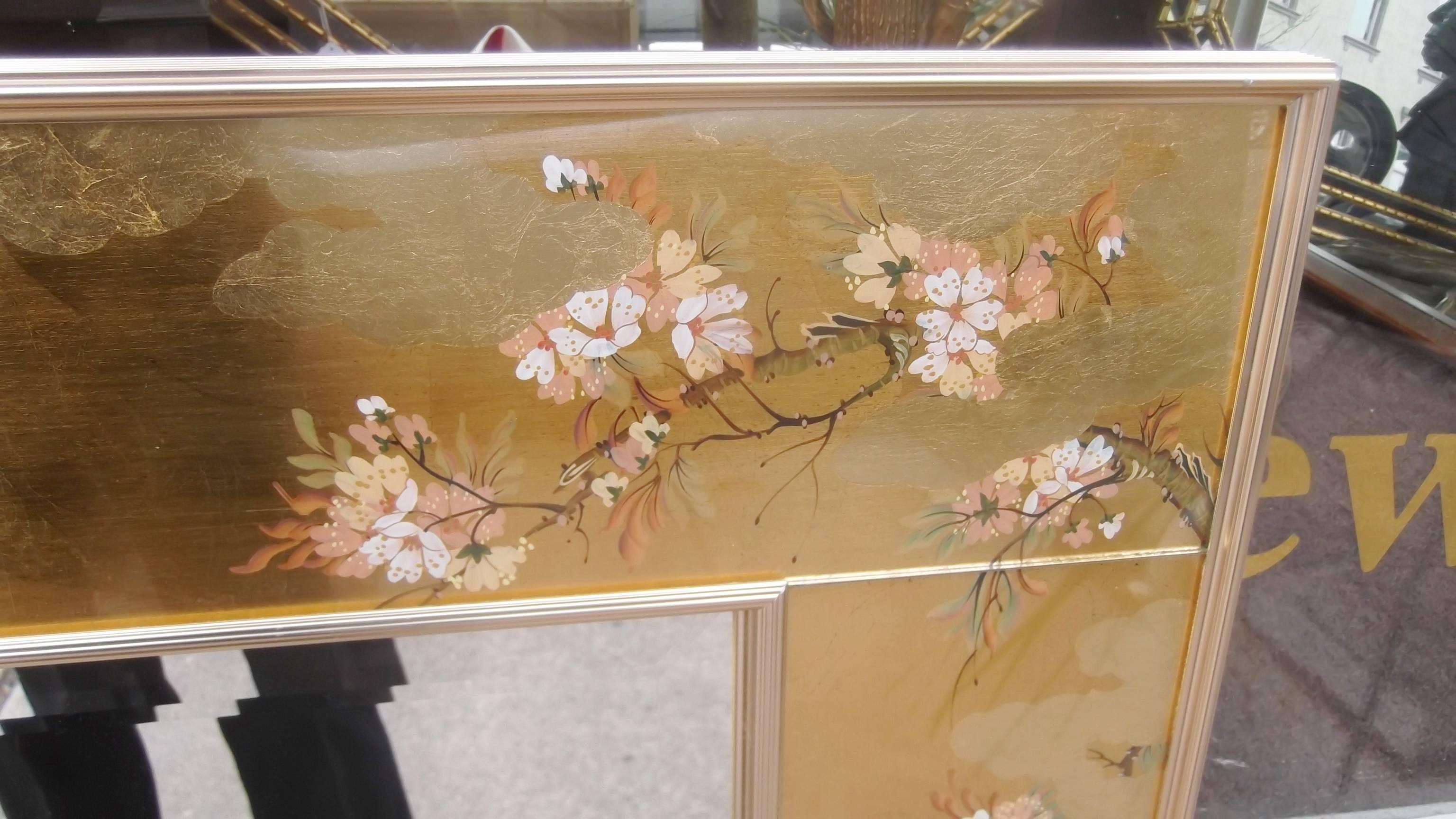 Beautifully reverse hand-painted églomisé beveled mirror.
Made by Labarge, the premiere mirror company, this mirror was artist signed by one of the companies expert hand painters. A rare landscape format, this large mirror is wider than it is