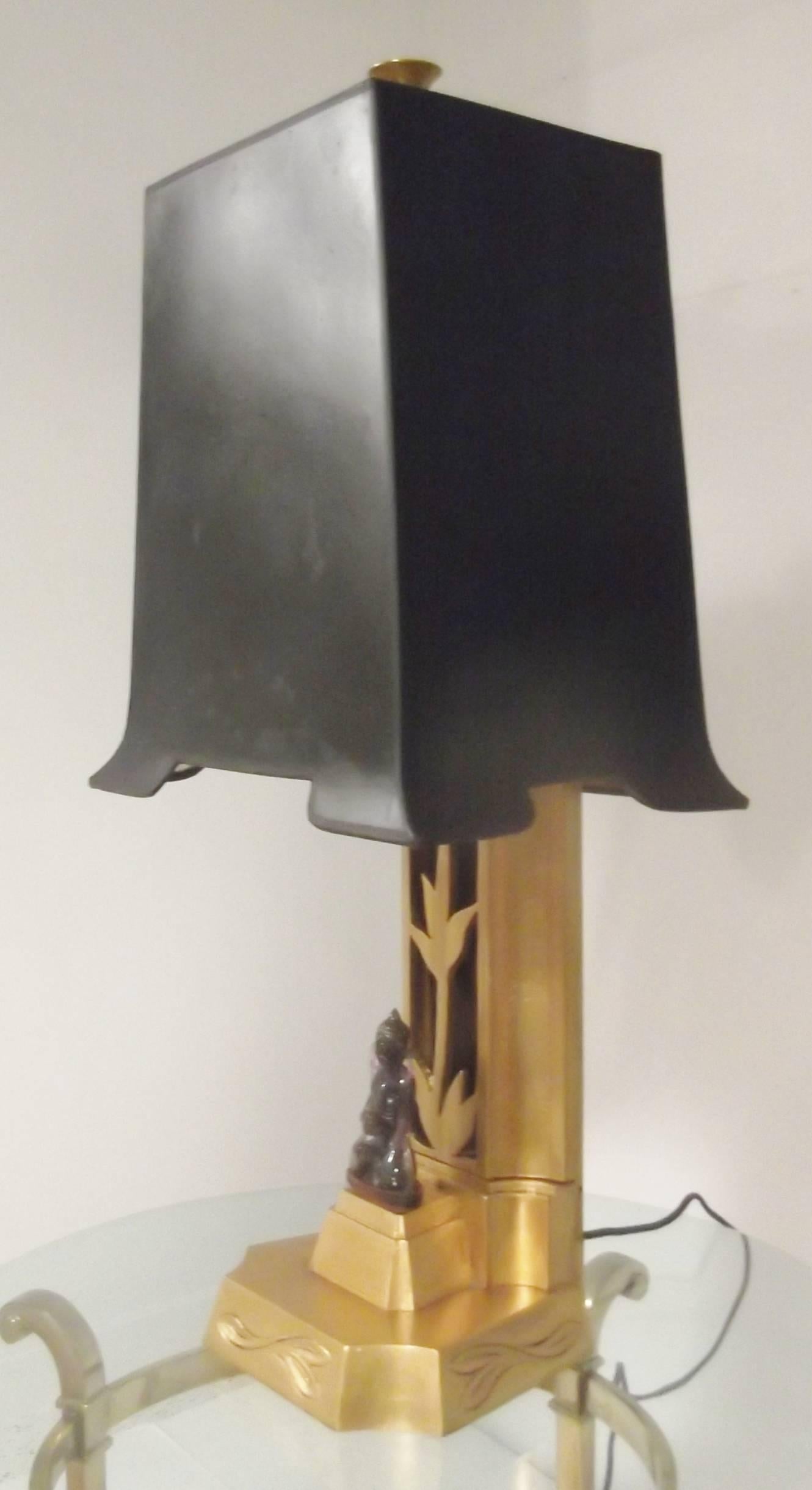 Rare and impeccably styled James Mont lamp with original black pagoda shade. The shade is a mat black with a gold foil lining.

The feature design element is the carved purple quartz Buddha with a distressed mirrored back drop. The flared finial