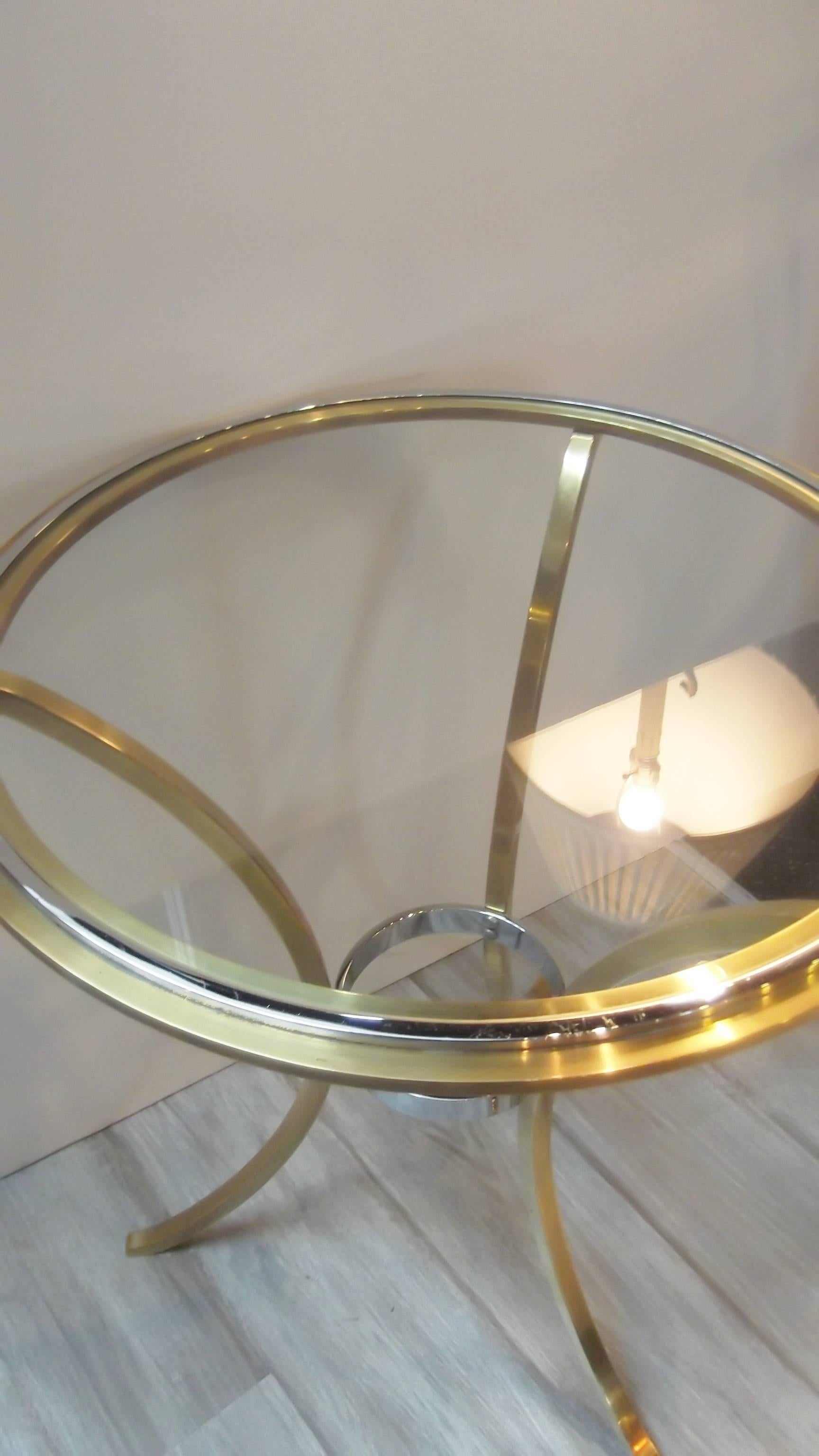 Elegant Maison Jansen chrome and brass accent table. The glass top is neatly fitted into the round cast brass base with a contrasting chrome detail. The table is a nice medium size and perfect for a city apartment. This is a cast body with good