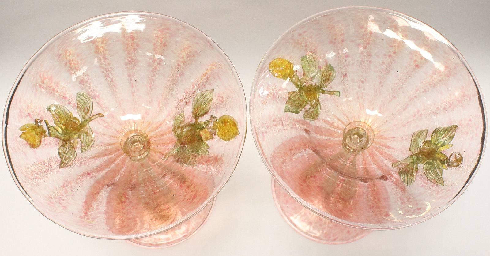 Pair of Venetian glass compotes in pink with gold dust and ribbed stems. Completely hand made by Italian master glass makers on the island of murano in Italy. Charming glass clusters of leaves and flowers adorning the sides, circa 1910 and