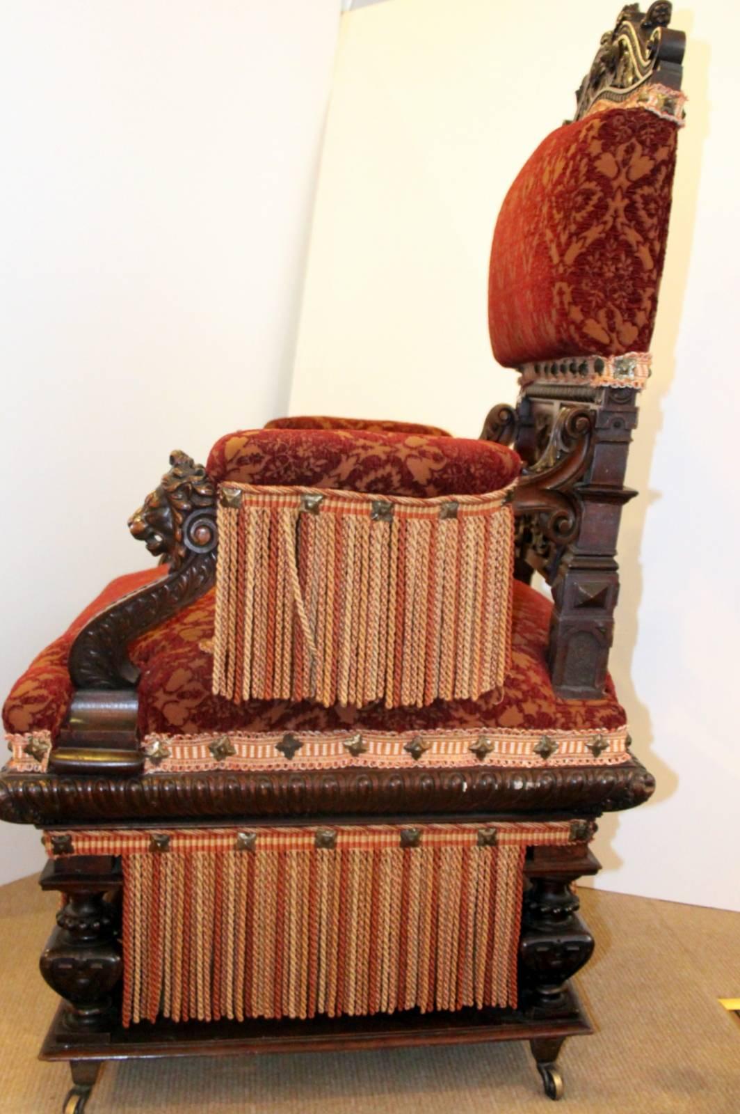 An expertly carved Renaissance Revival gentleman's chair. Carved walnut with new upholstery. The upholstery is very appropriate to what this chair would have from the middle of the 19th century. Lavish fringe with nailhead trim are also very much in