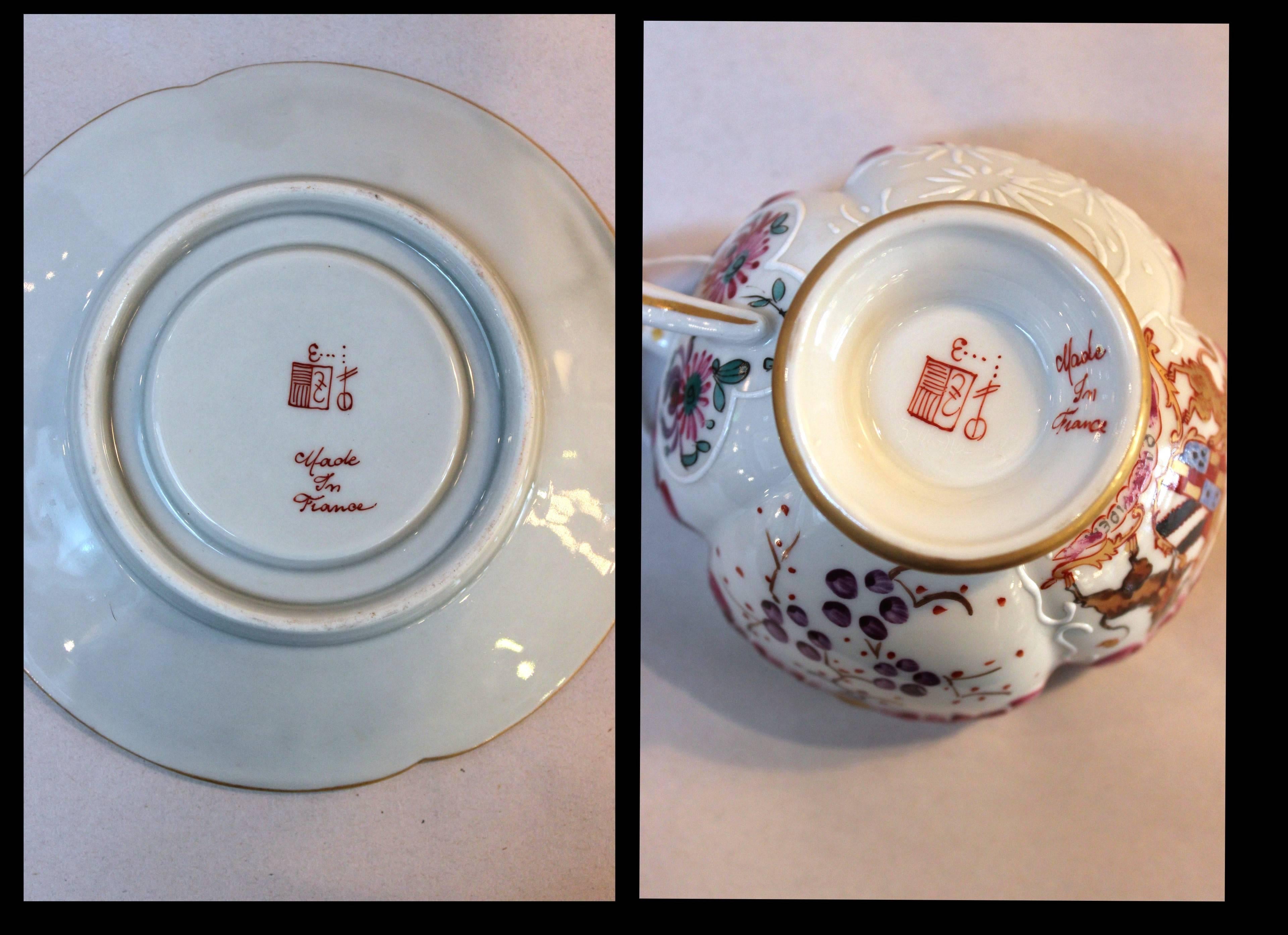 A set of eight armorial French porcelain cups and saucers made by Samson. These are in the Chinese export style, each one individually hand-painted with different armorial crests. Delicate coral scrolling design around the rims. The cups and saucers