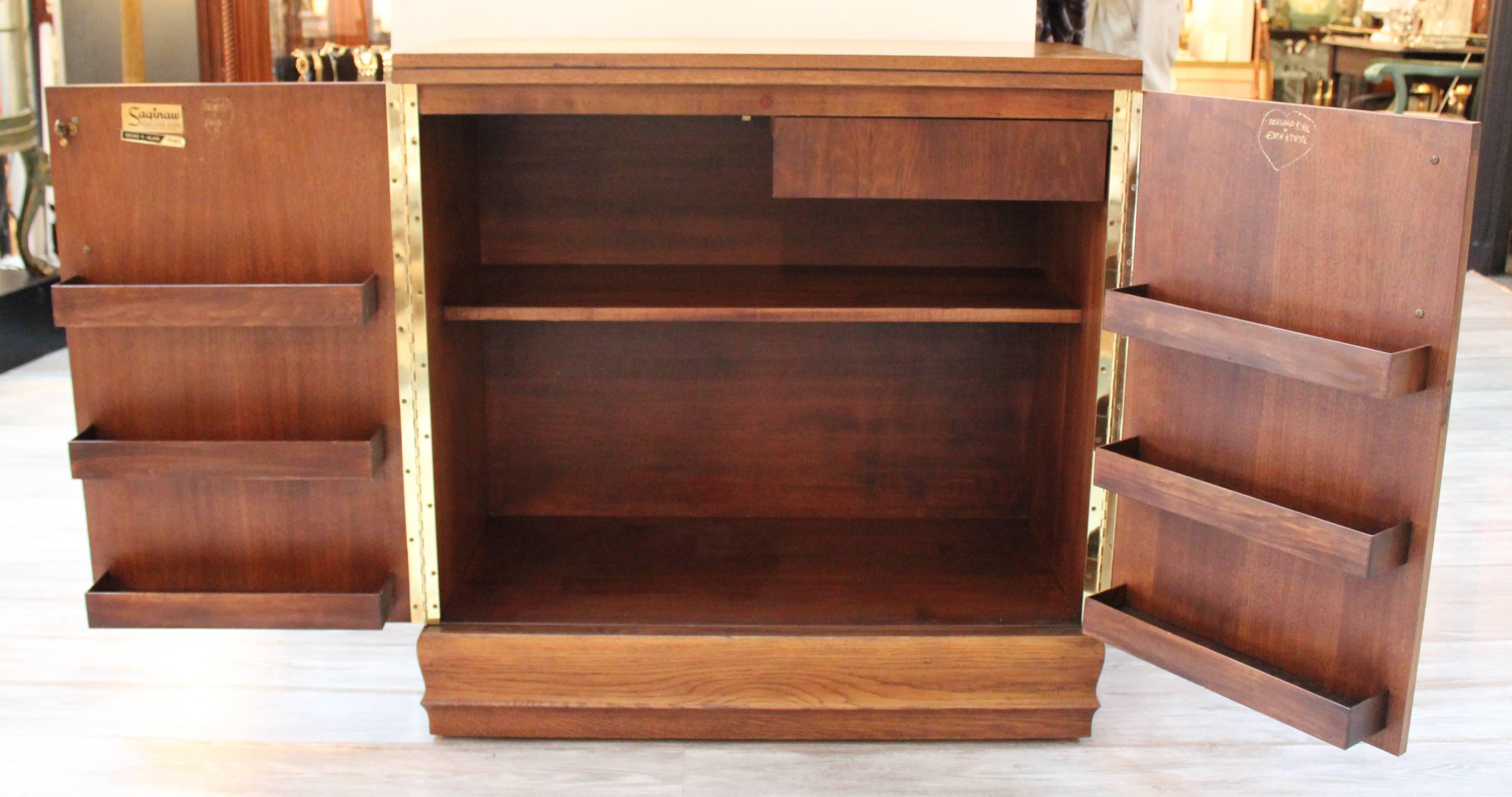 Medium stain mahogany flip-top bar with back formica top (when opened).
Two doors reveal shelving and storage for a well stock bar. Marked 
