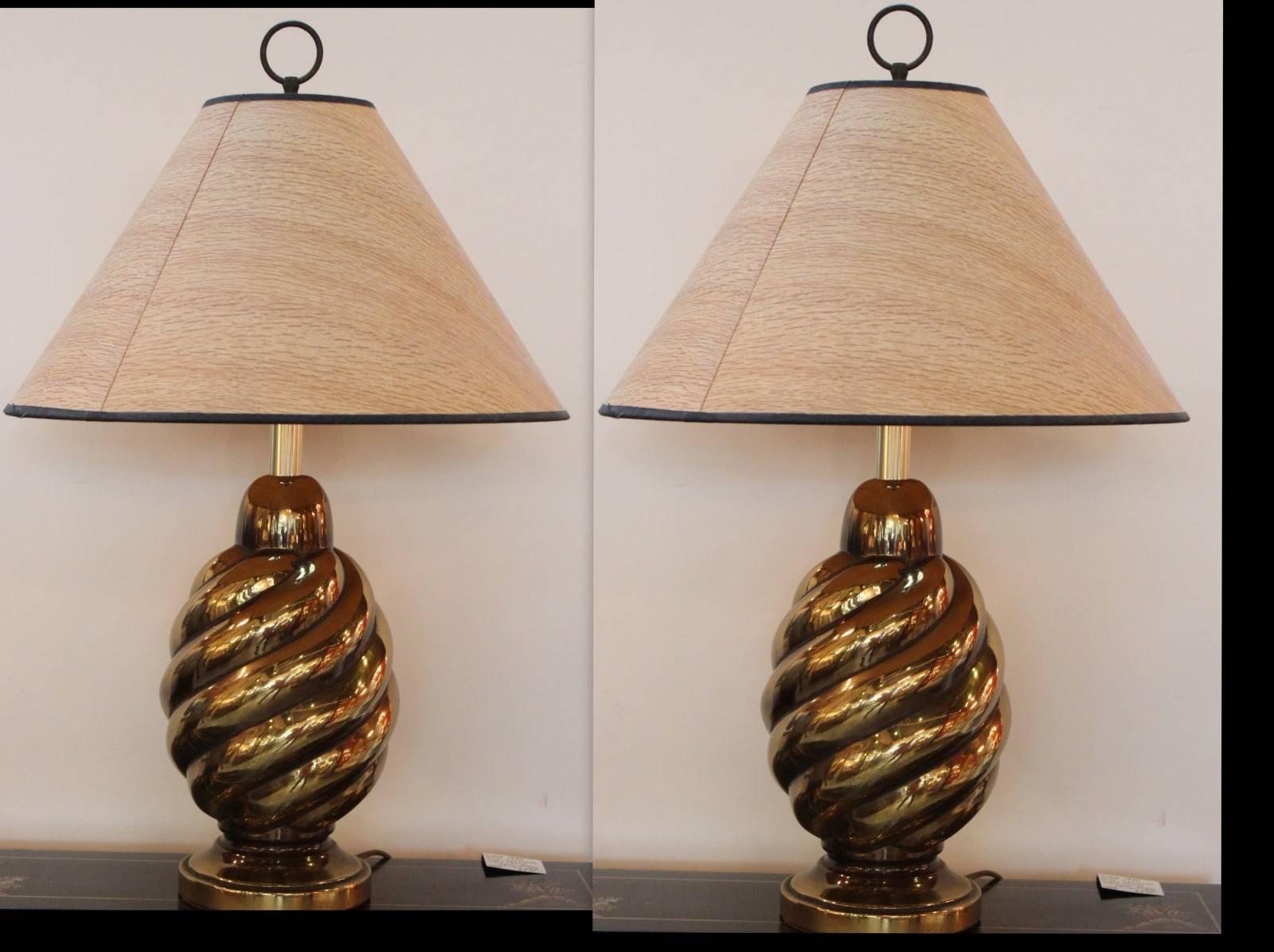 A pair of chic European continental table lamps in brass with a swirl-form body.  The shades are for photographic purposes only and not included with the lamps. 
Â Â 