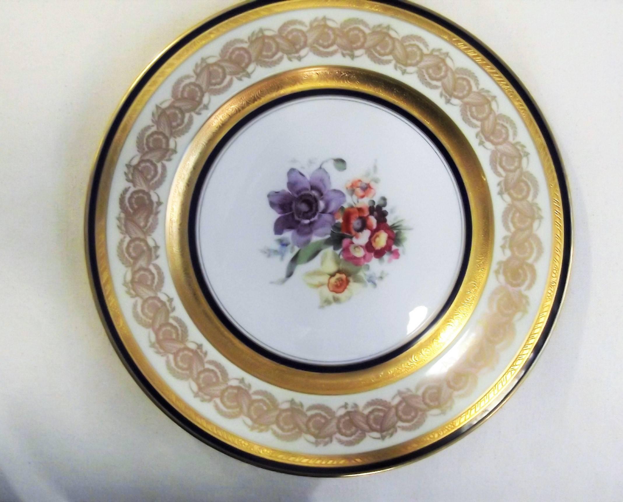 Exceptional set of twelve vintage bone China plates decorated in 22-karat gold by E.J. Grimm. beautiful floral center medallion surrounded by bands of cobalt blue alternating with raised gold encrusted bands and a detailed flower and leaf scroll