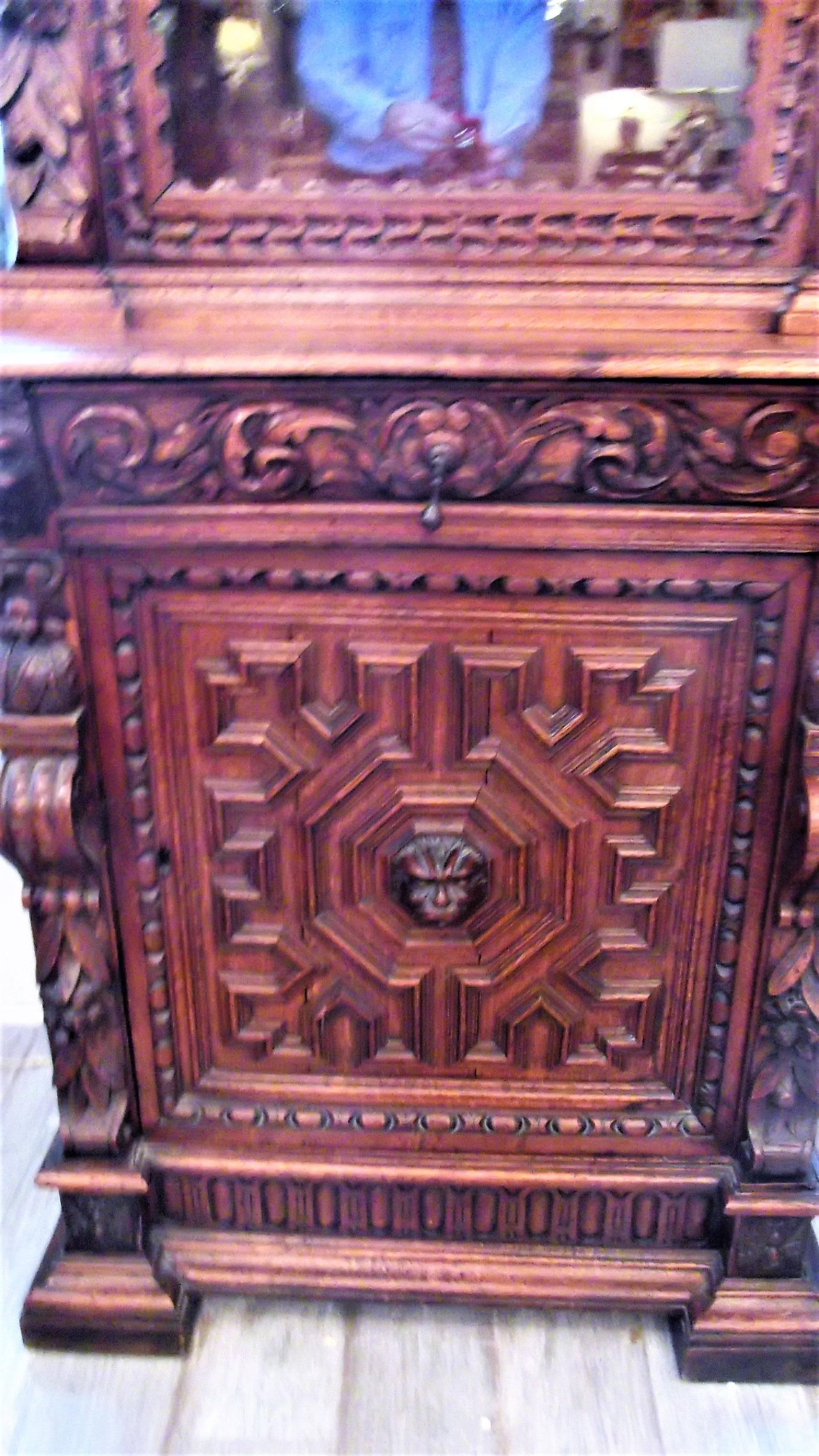 Beautiful hand-carved oak English cabinet in the Renaissance Revival style. A single glass door reveals two carved shelves. The lover portion is a carved door which reveals a shelved storage compartment.
