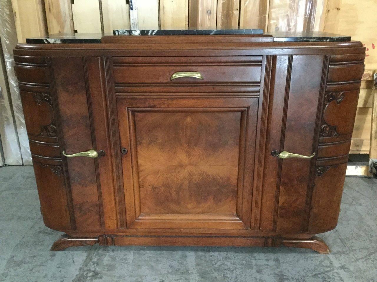 This period 1930s French Art Deco buffet features two rounded side doors for
storage, a central door and a drawer. Made of solid walnut, the top
features three elevated pieces of black marble with white veins. Carved accents
on the doors reflect