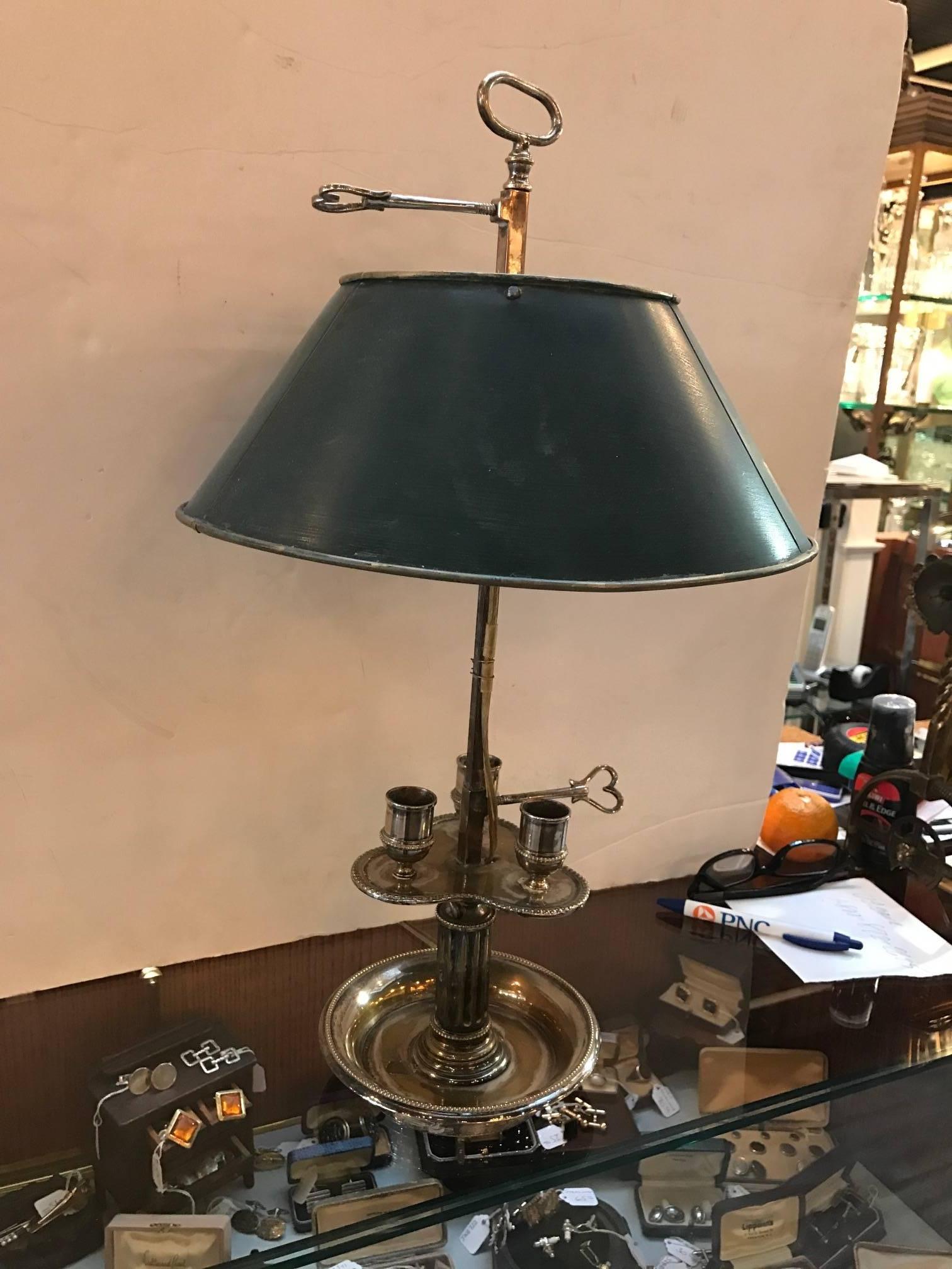 Very early 19th century silver plated brass French Bouillotte lamp. This lamp originally used three candles and was electrified in the early 20th century. Probably the original tole shade slightly bent with wear to silver plating but all original