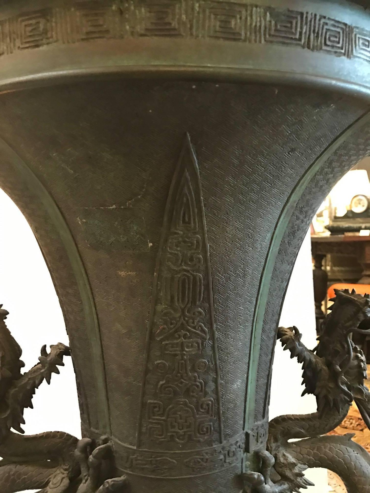 A monumental antique Japanese floor vase, Meiji period, 1880s. Antique Japanese copy of a Chinese Gu form oversize vase. Signed on the bottom, this vase is patinated in the original oxidation, some pitting, old repairs and flaws in the making.