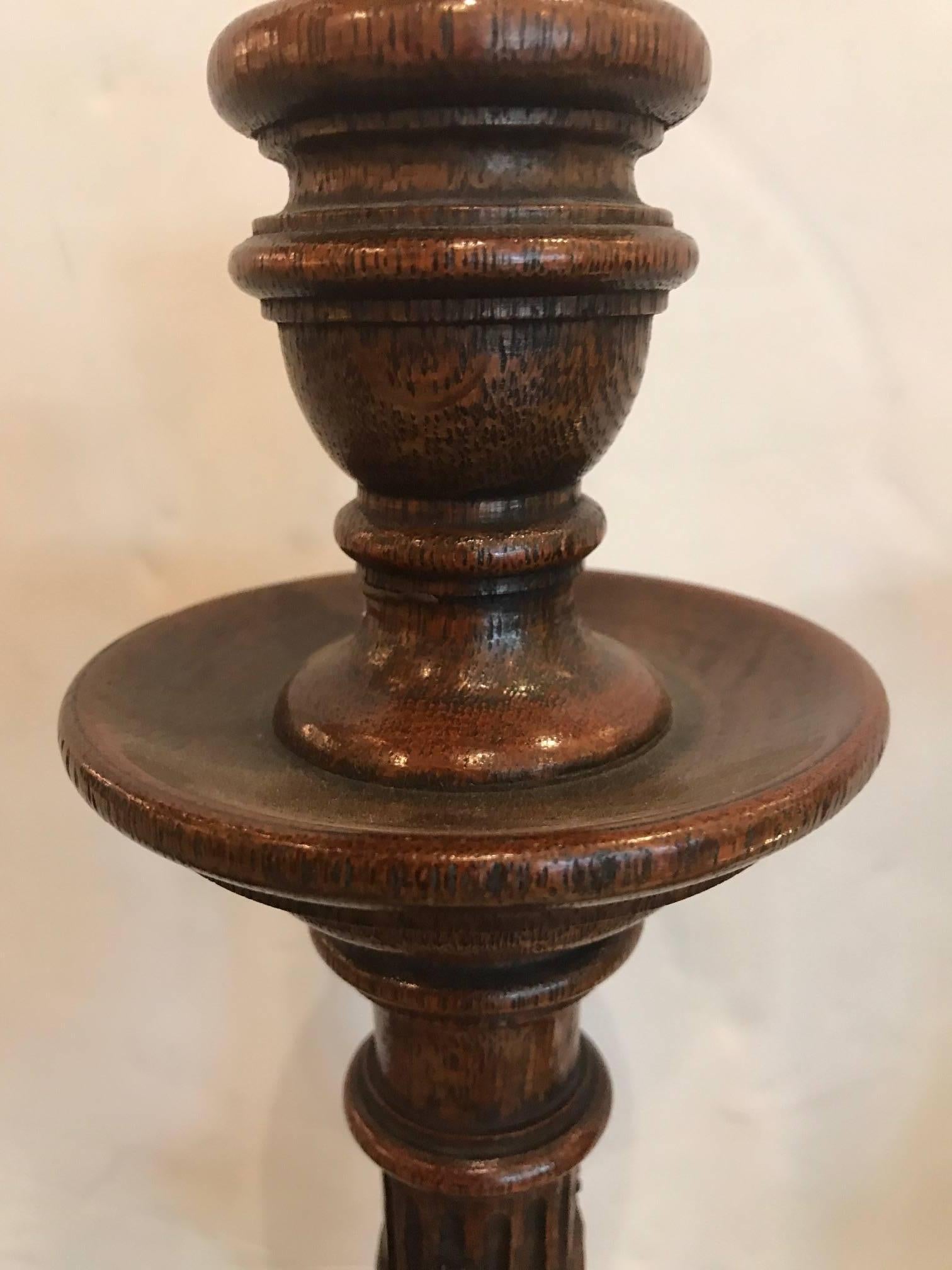 The urn form column with acanthus leaf decoration supported by tripod carved bases with paw feet. The feet have brass balls on the bases which are weighted.