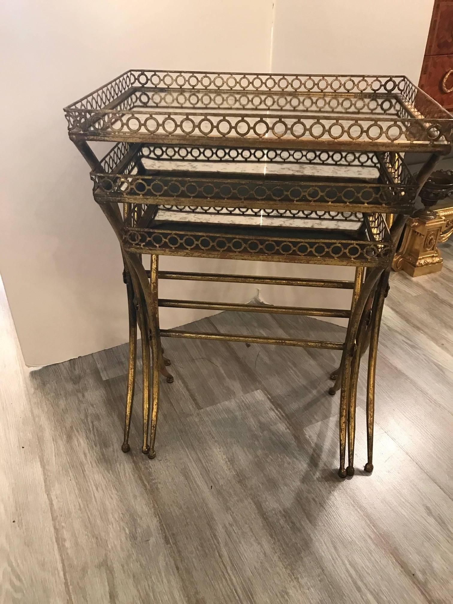 Diminutive set of Italian gilt metal and mirror nesting tables. Each one fits neatly into the other and can be displayed very compact of stepped out showing each one separately.