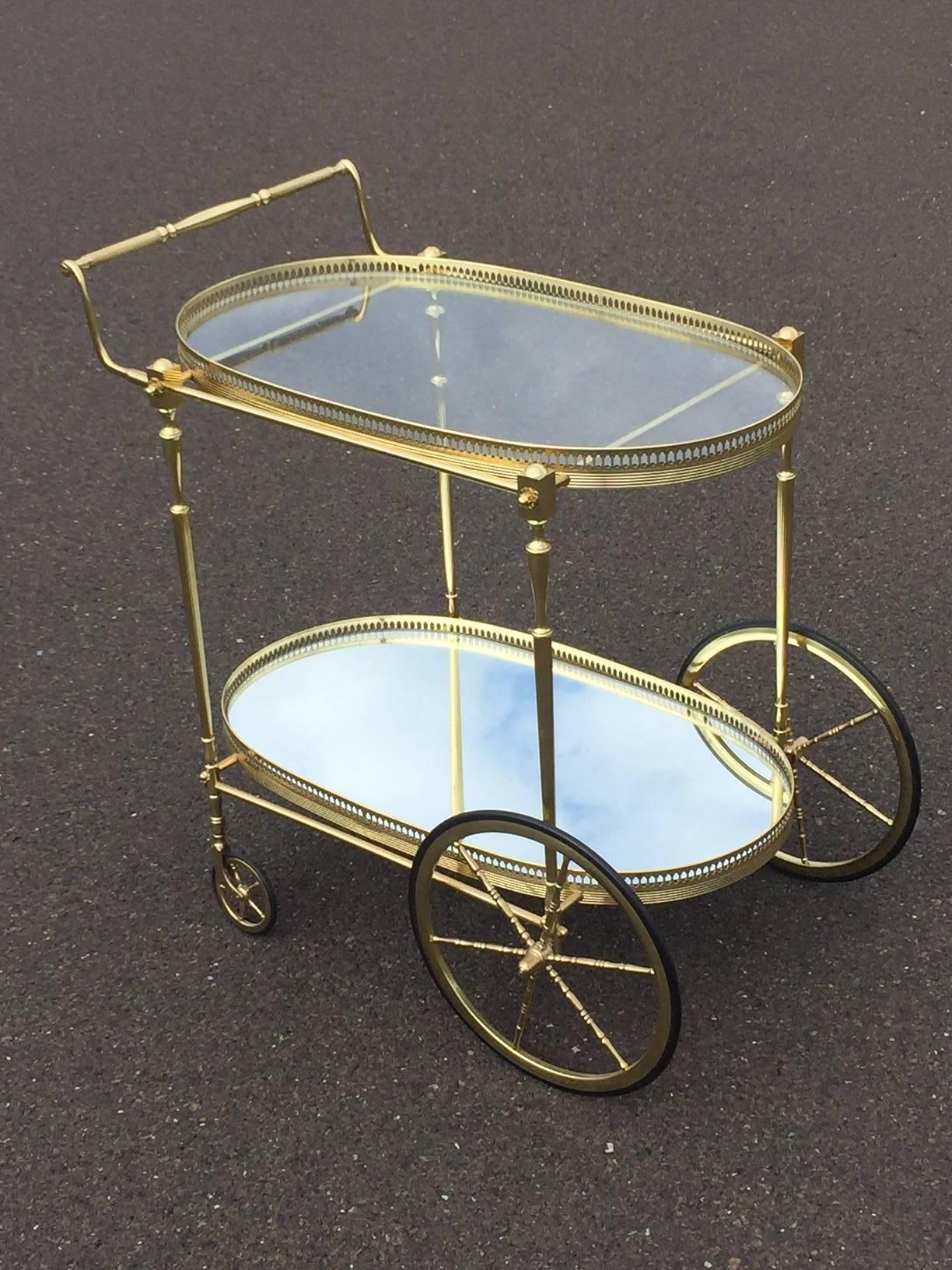 Polished brass Labarge Beverage cart with gallery tiers. Chic oval shape with large bicycle style wheels on the back. The lower tray is mirrored giving the card more substance.