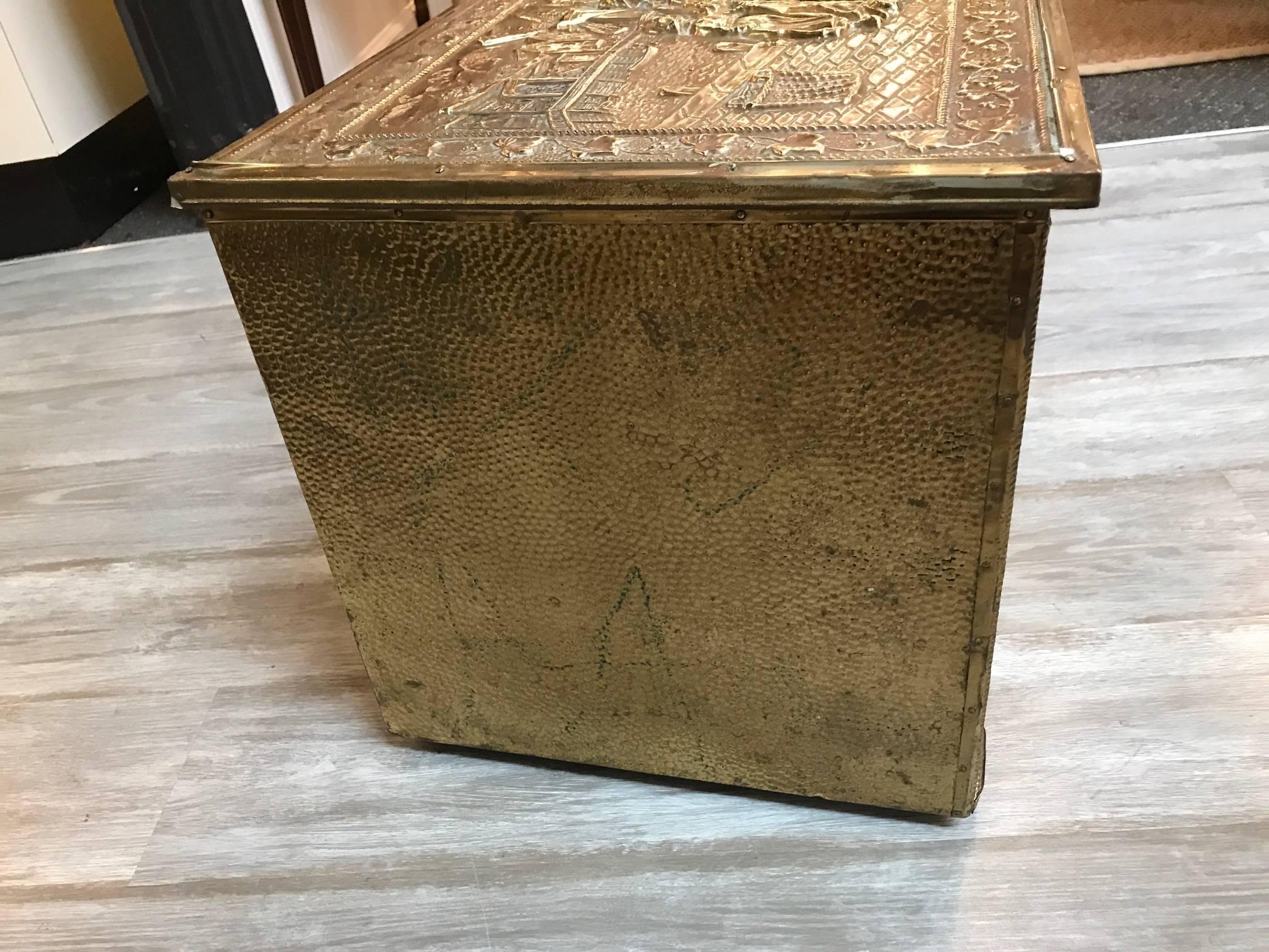 Early 20th century brass tinder box. The wood box with high relief brass sheeting on the front, sides and top with hinged lid. A perfect way to store kindling or duraflame type logs neatly next to a wood burning fireplace.