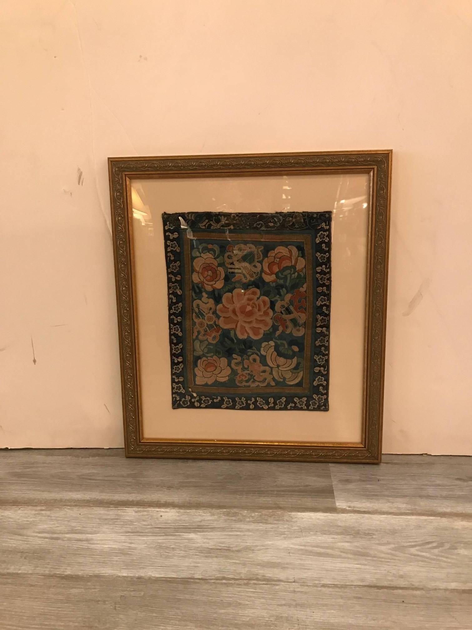 A silk panel with silk embroidered floral center from the 19th century and hand made in China. The panel is attached to an acid free backing with giltwood frame with UV glass. exquisite detail with some signs of age in the corners of the silk panel.