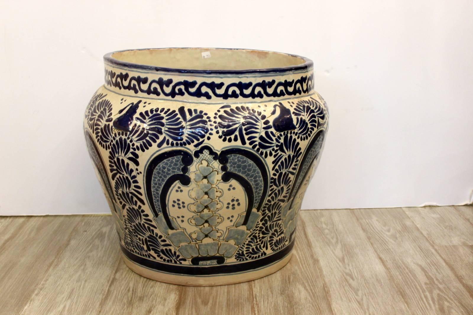 Large blue and off-white hand thrown planter jardiniere with hand painted design. The cobalt blue painting is over a cream background. The artist name is signed on the base. Marked Puebla Mexico.
