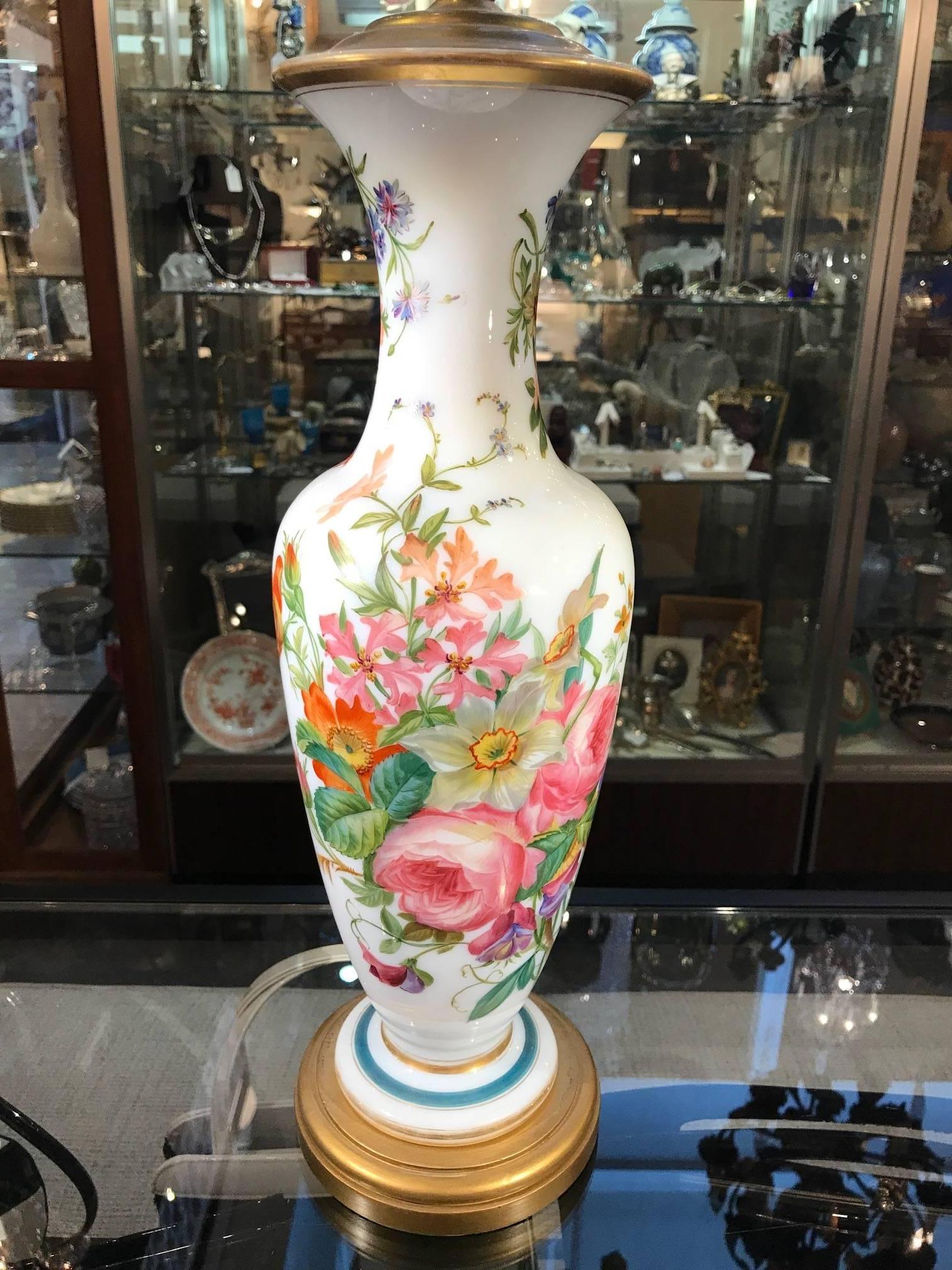 An opulent Baccarat opaline glass vase now electrified with floral paintings and gold painted border frieze attributed to being decorated in the workshop of Jean-Francois Robert, circa 1840. Roses, poppies and chrysanthemums are among the luxurious
