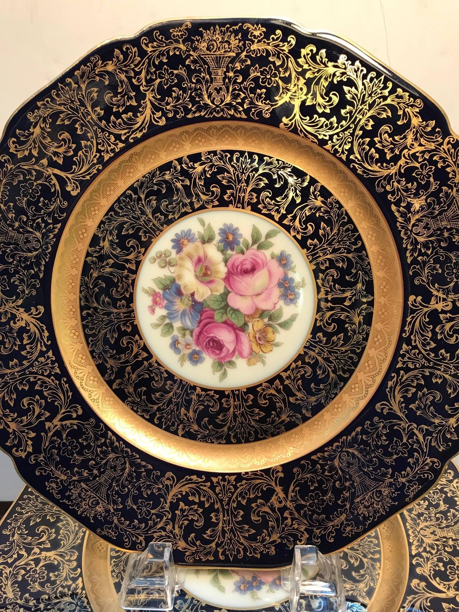 A set of cobalt blue with elaborate gilt border floral service plates. Double ring broad borders with central Dresden floral medallion. The plates are in unused cabinet condition with one plate having a scuff wear to the gilt border. Opulent and
