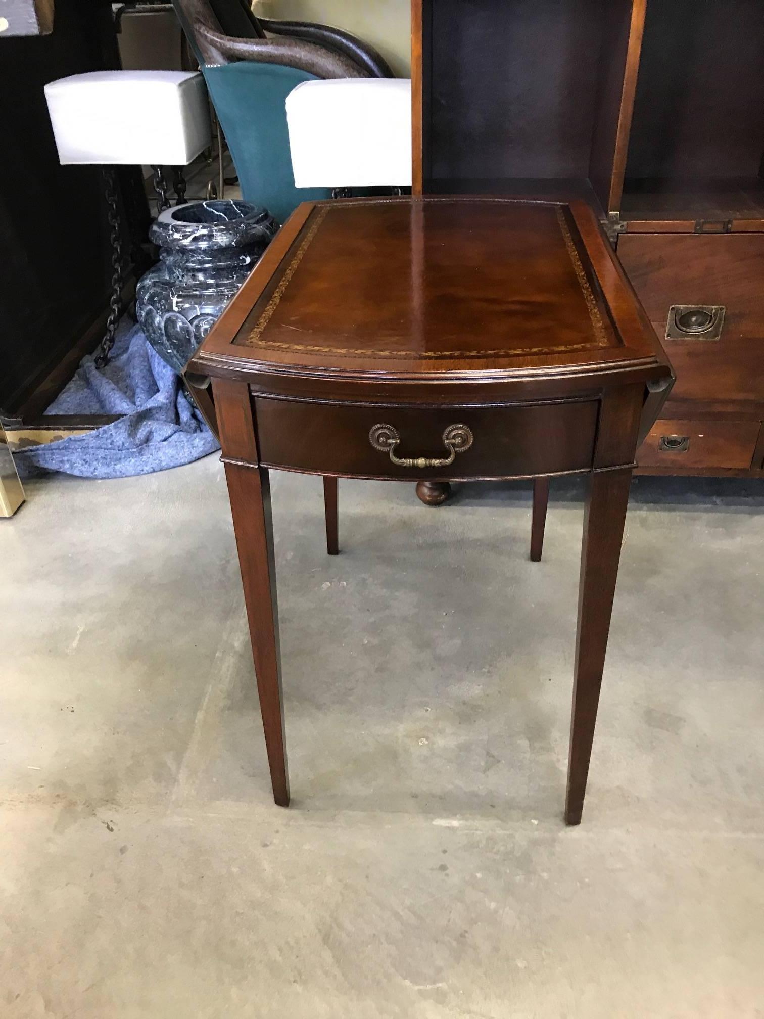 Versatile pair of mahogany pembroke tables with leather tops. The leather tooled tops with centre front drawer supported by four tapering legs. Timeless and classic. The leather is in very good condition showing with no tears and very durable. It