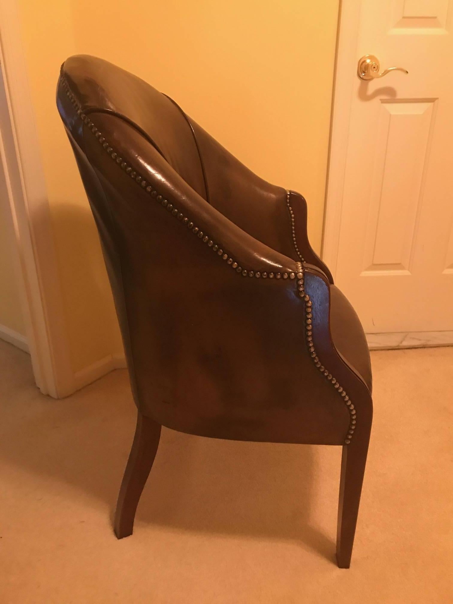 Diminutive English leather library chair with mahogany frame and brass nailhead trim. The attached seat and back in a dark olive brown leather. The leather has some creasing but has not tears. The scale is meant for a smaller person.