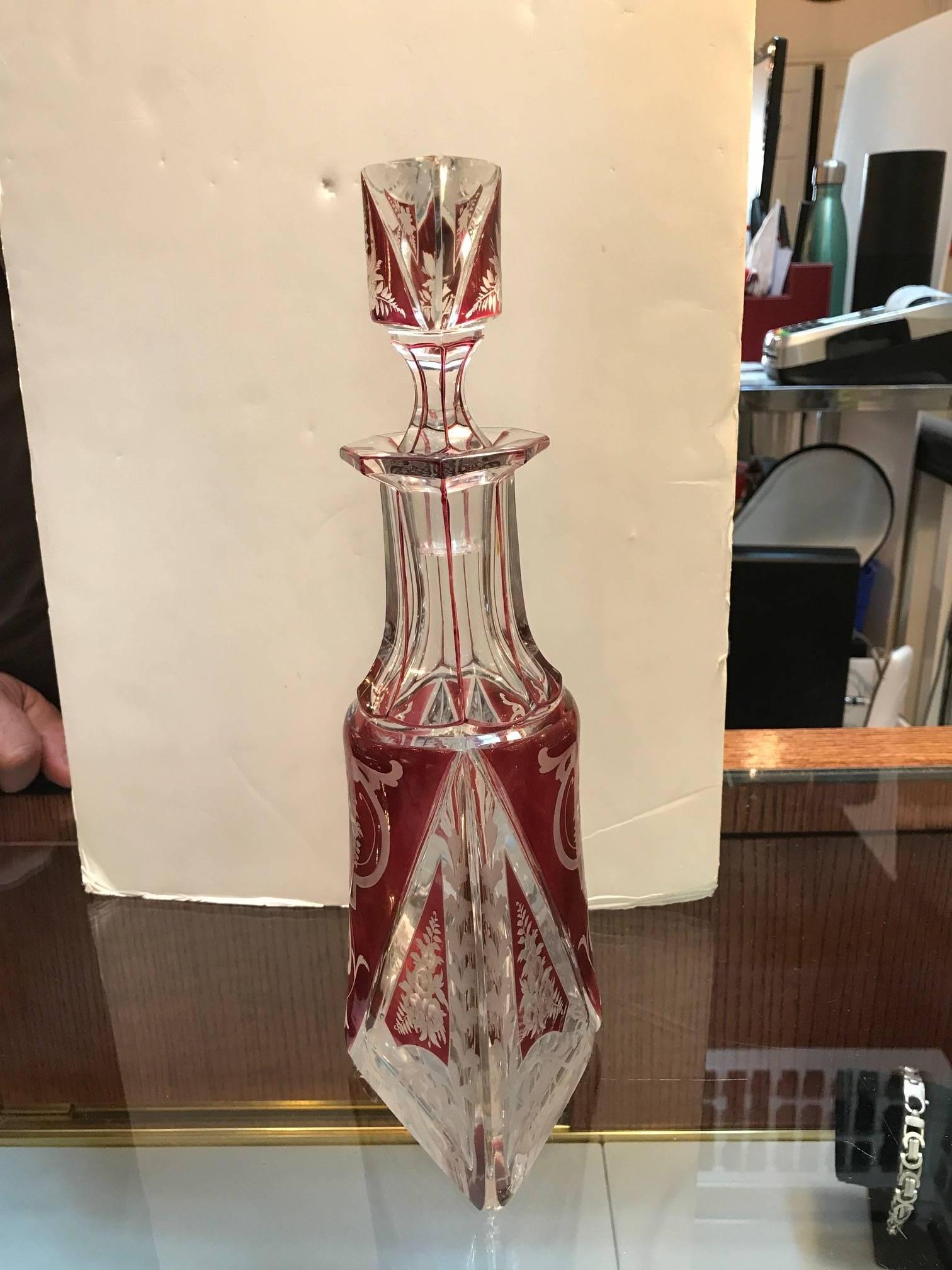 Graceful and elegant intaglio cut-glass tall decanter with original stopper. Panel cut neck with magnificent engraving of floral panels all around. The Violet highlights with a clear cut highly detailed design. Exceptional quality.