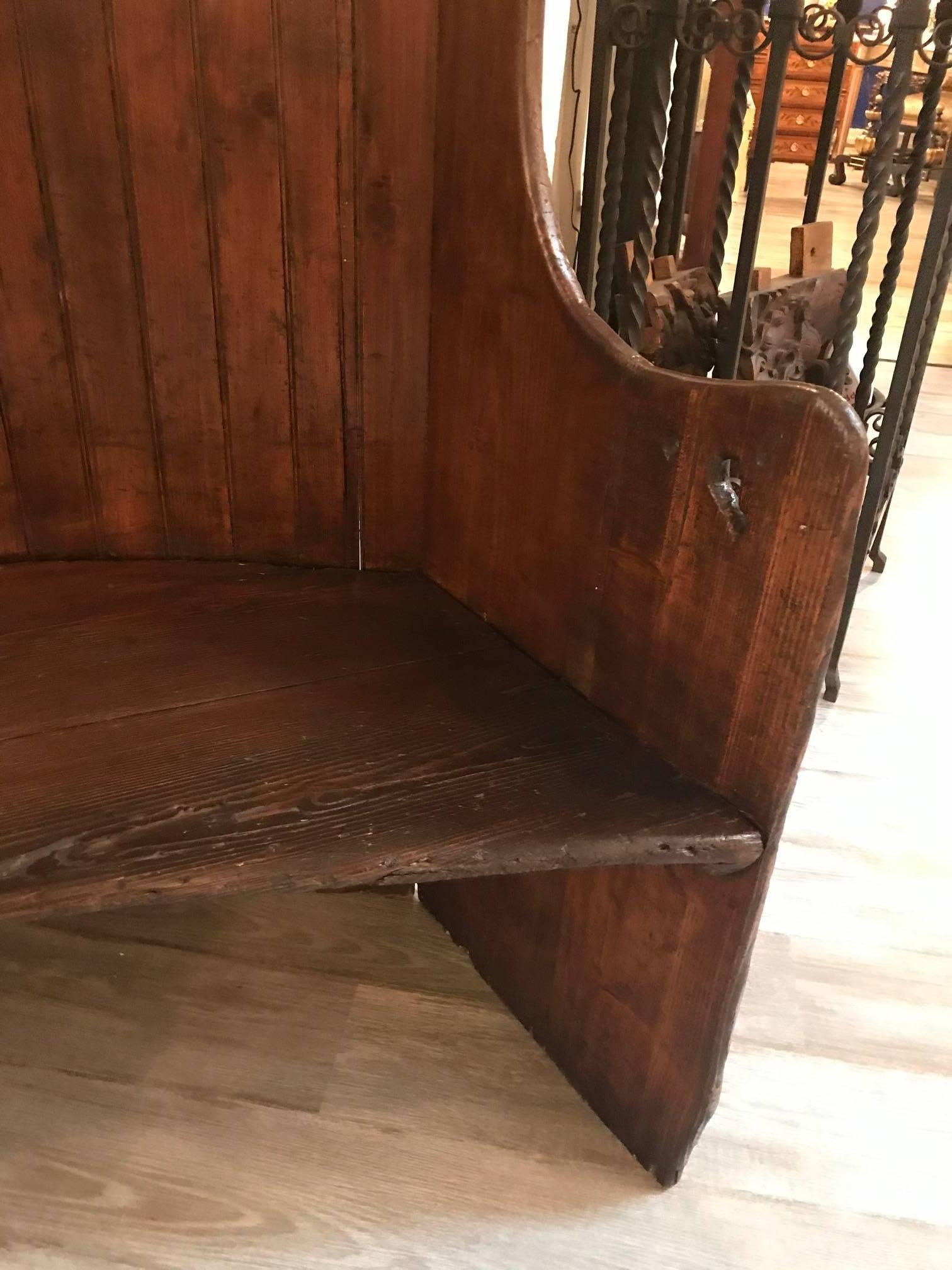 An antique English settle bench with hand-forged old iron braces. The gently curved back with traditional winged sides.
A settle is a wooden bench, usually with arms and a high back, long enough to accommodate three or four sitters.
Settles are