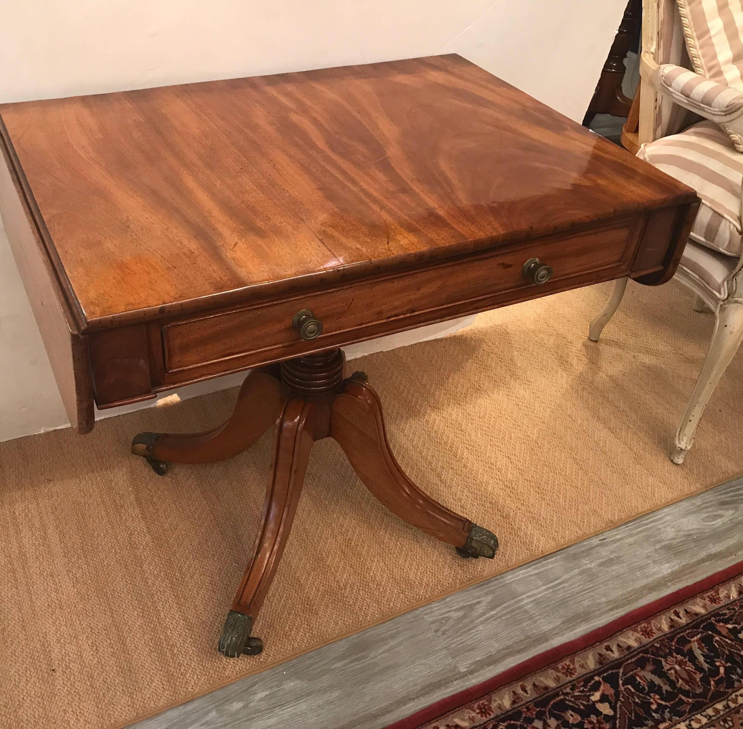 Classic drop-leaf mahogany sofa table writing desk. The single drawer with a duplicate faux drawer on the back. The recent French polish enhances the nicely figured grain of the wood. The leaves add 6 inches to each side. Overall length with the