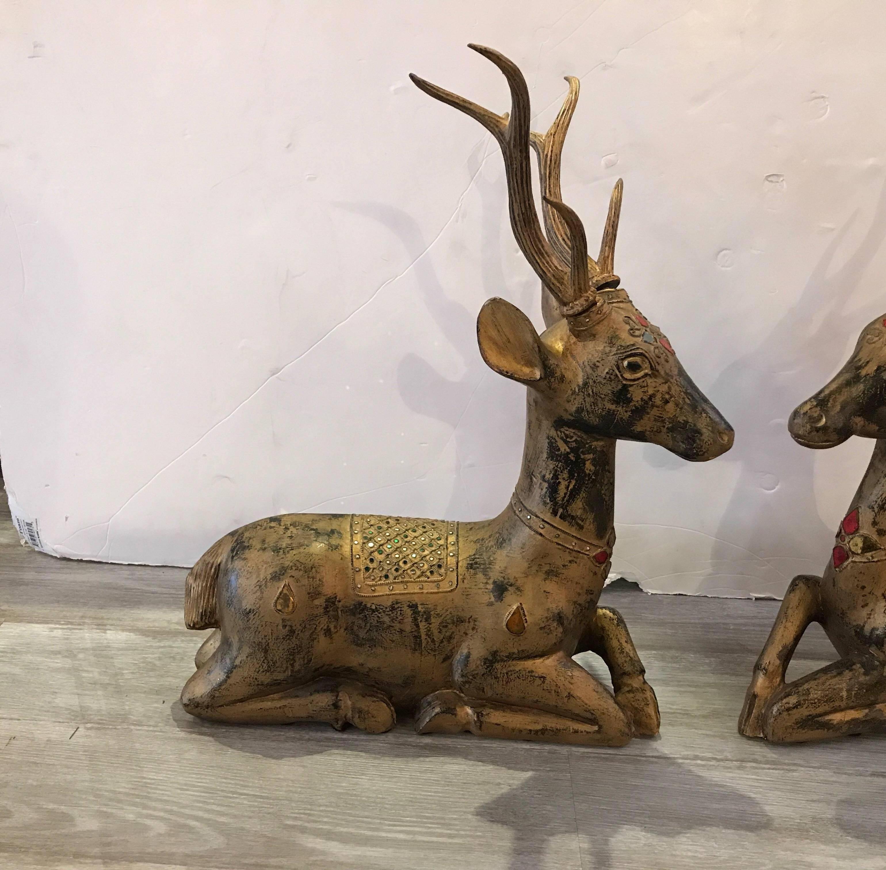 The carved wood figures with original slightly worn gilt finish. Each one a mirror image of each other. The surface with small mirror jewels on the head and front. The carved wood antlers are removable.