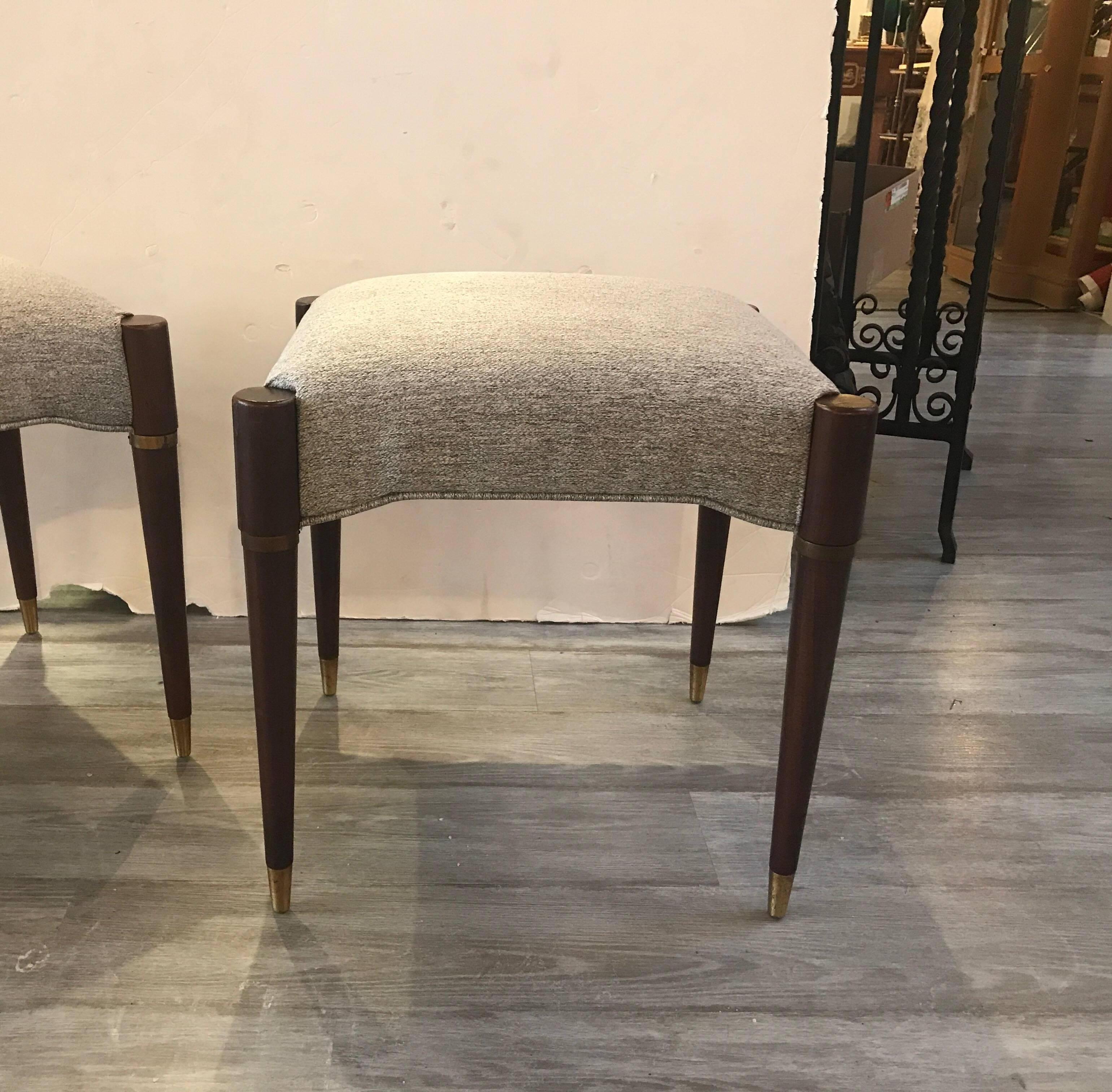 Chic pair of walnut Danish modern benches. The tapering legs with brass ring towards the top and brass cap on the foot. The new fabric is a neutral woven lightly textured cotton linen.