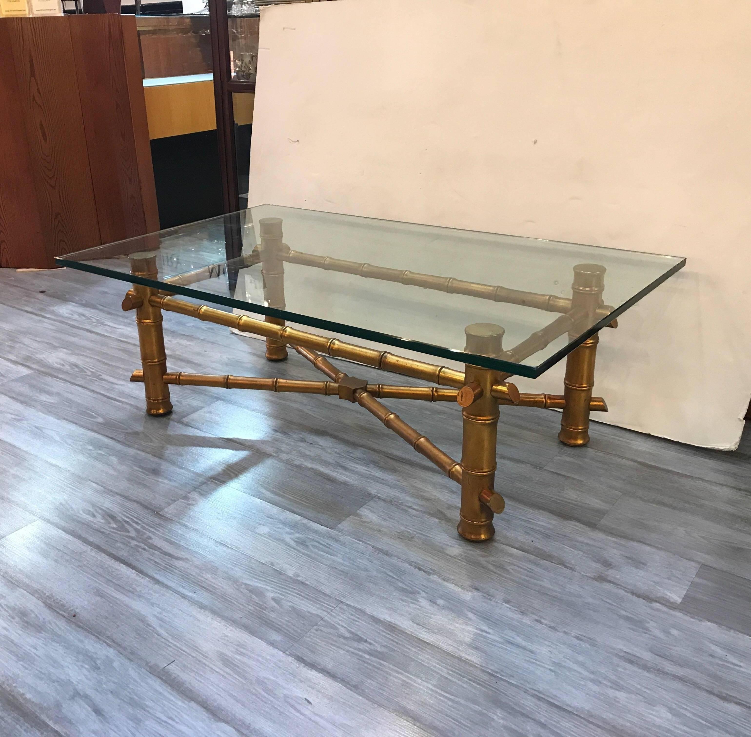 Hollywood Regency faux bamboo coffee table with thick glass top. The thick legs with bamboo style carving with sturdy X stretcher base. The top is a generous three quarter inch.