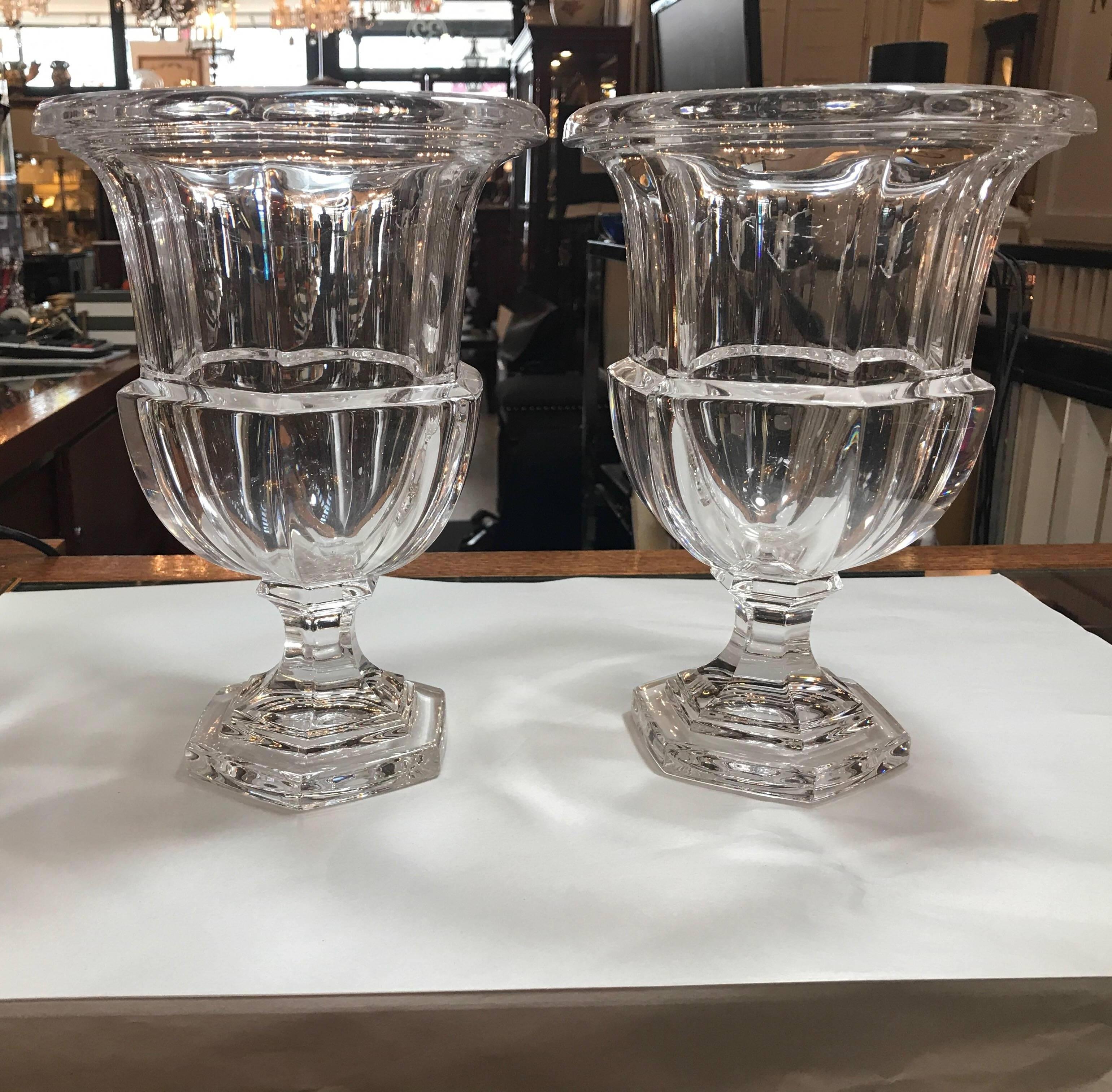 An elegant pair of high quality water clear crystal urns. The panel cut sides with rolled edge tops, urn body resting pedestal base. We have two pairs available.