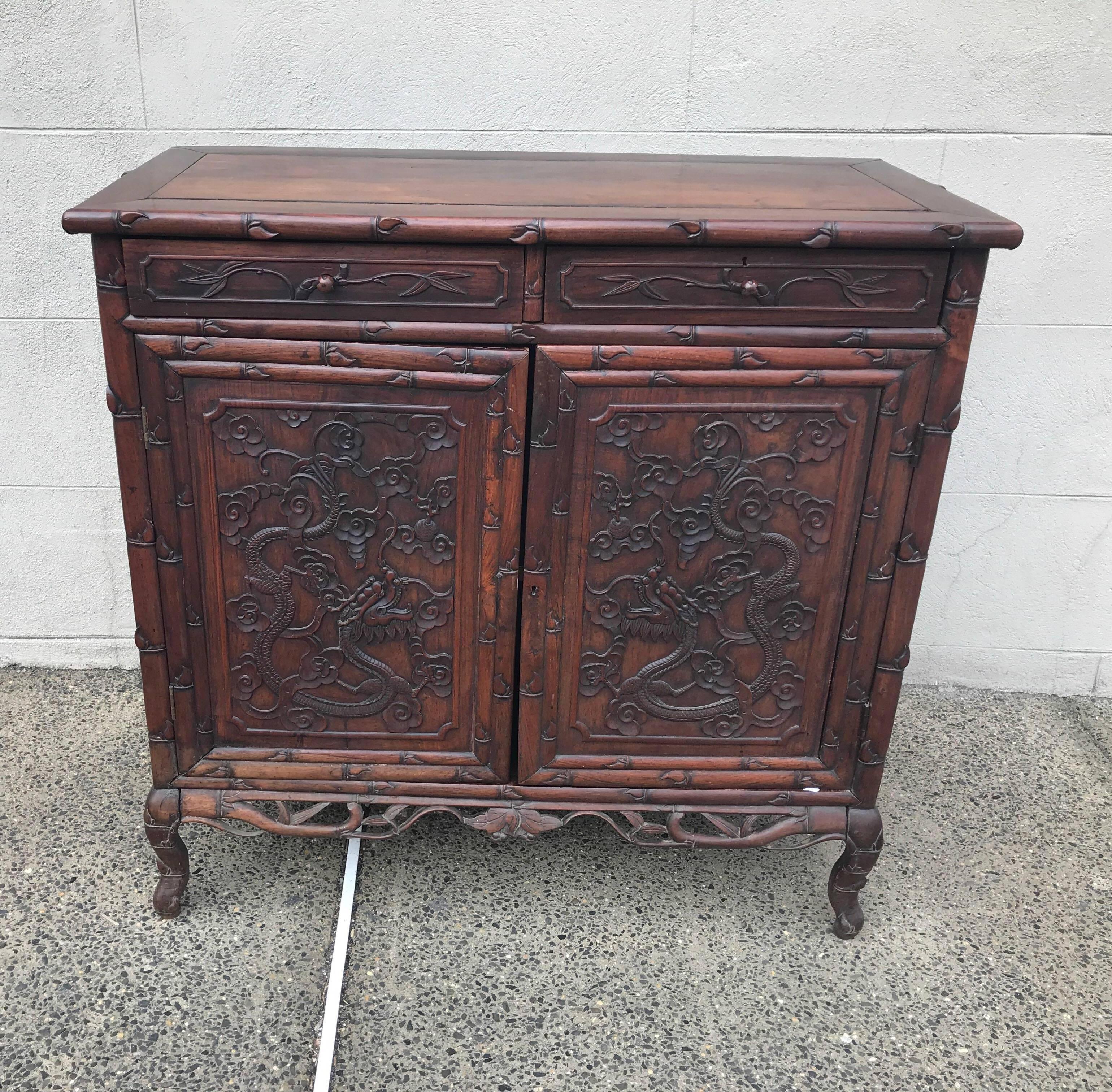Hand-carved 19th century rosewood cabinet. Exceptional relief carving with dragons and vine motif all around.