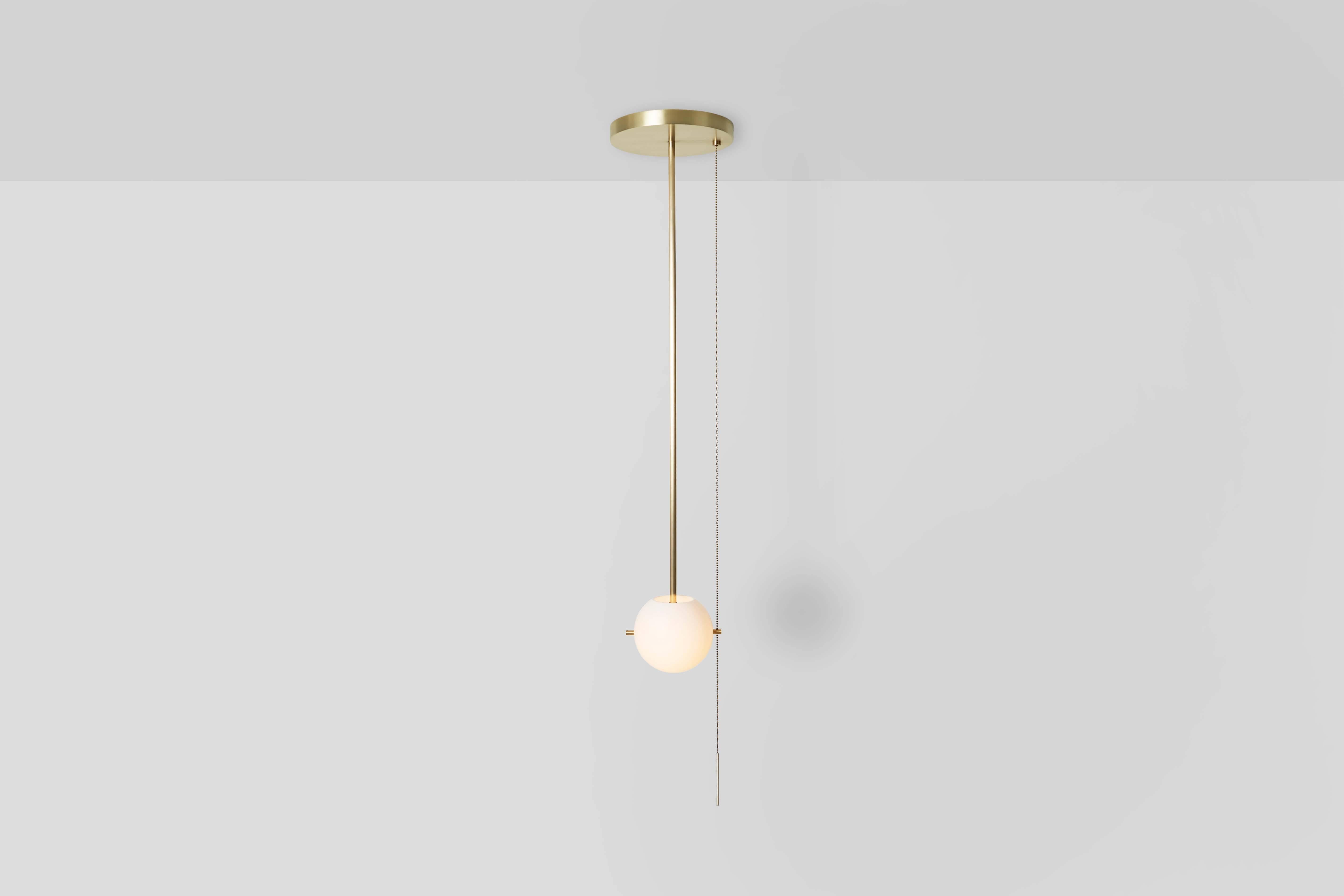 Le PENDANT SIGNAL / MONTAGE FLUSH présente un globe en verre soufflé à la main suspendu à une canopée en métal lumineux par une paire d'épingles en métal. Une chaîne de traction sinueuse est lestée par une barre élancée, conférant à la pièce une