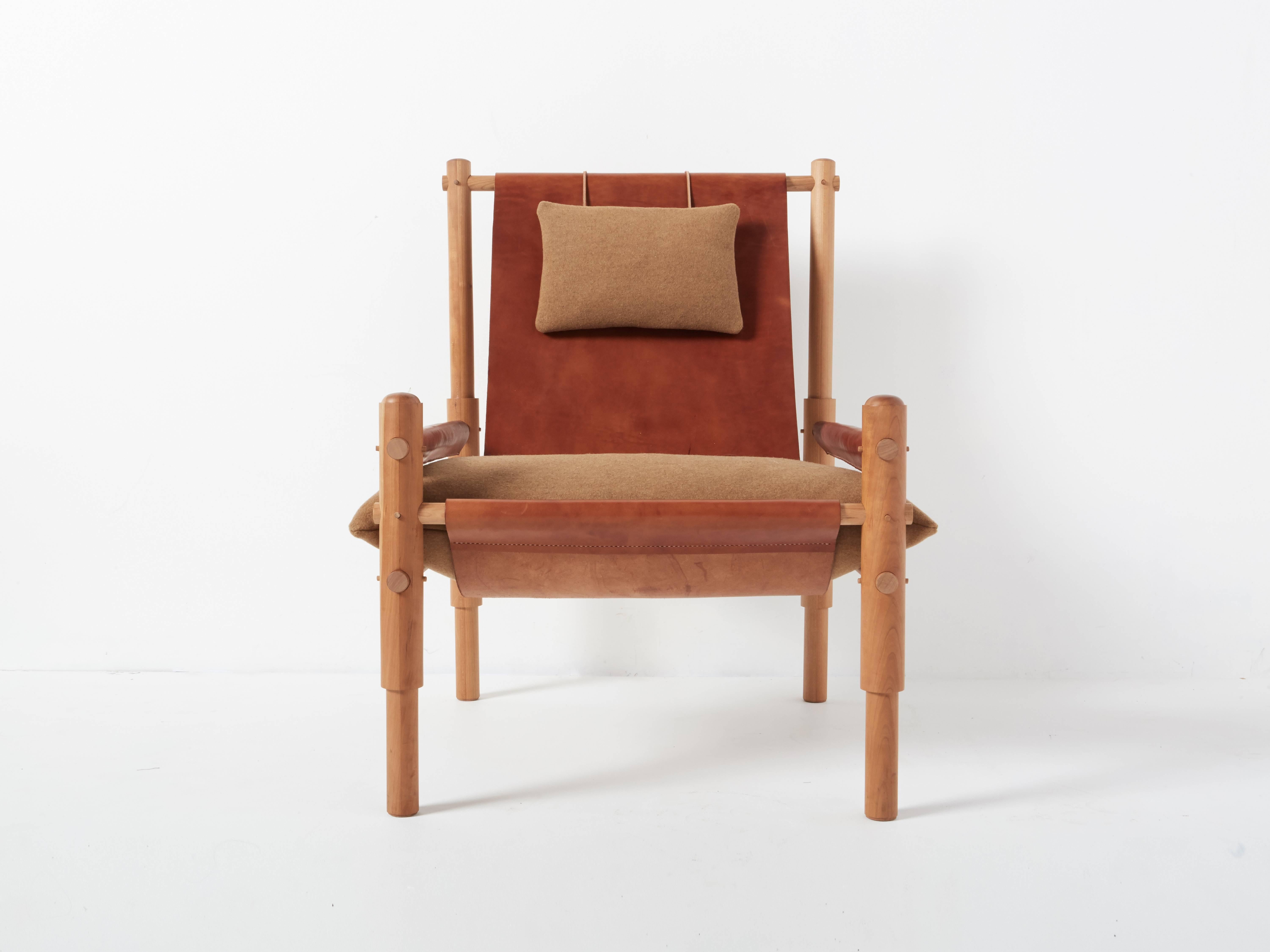 The Sling chair two is an elemental take on Campaign-style furniture, with a continuous sling fitted with two wool pillows and a turned wooden weight. The solidity of an articulated wooden frame balances the soft, owing nature of the sling form.