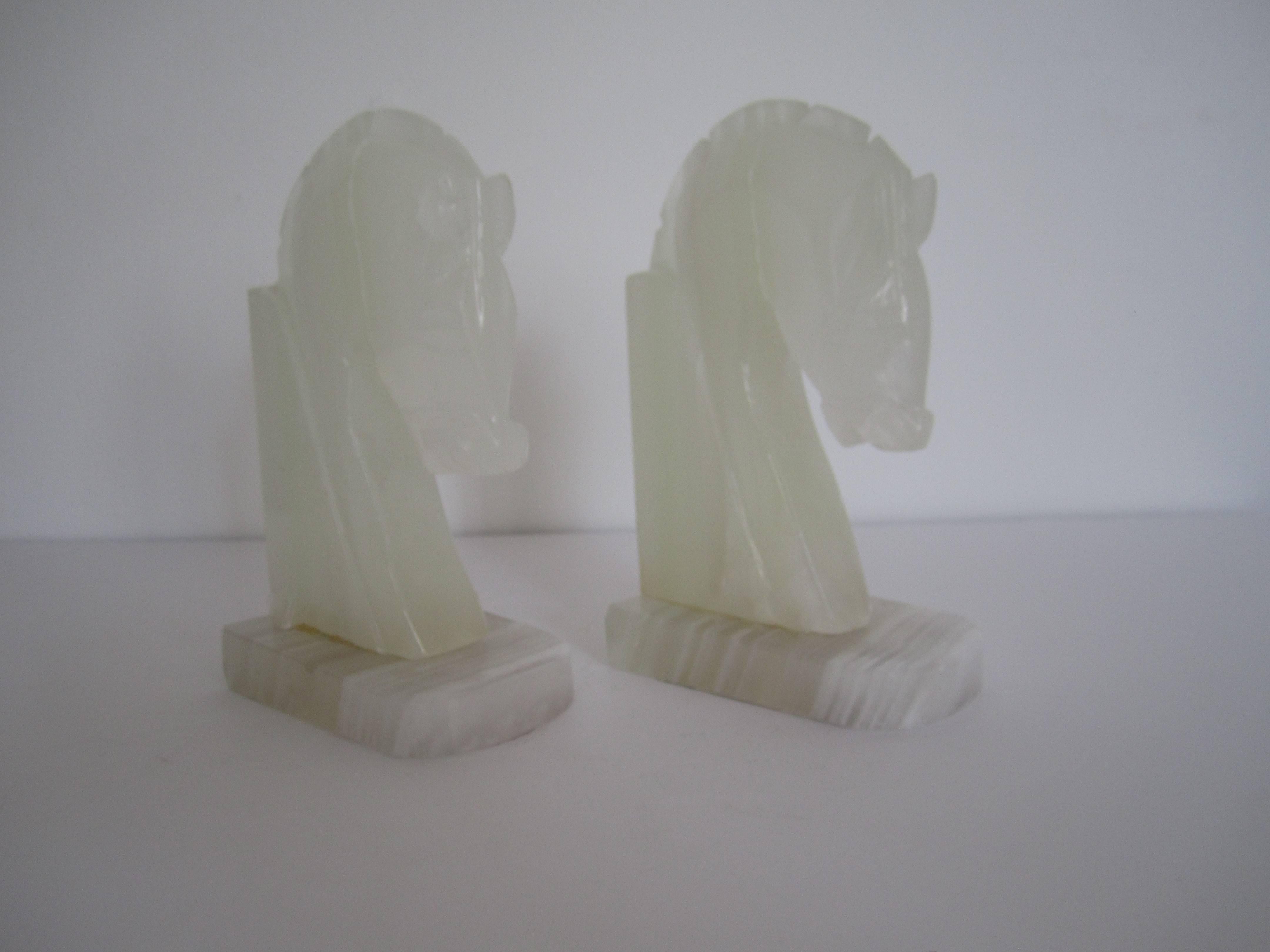 A vintage pair carved white onyx 'Horse', 'Trojan', or 'Equestrian' bookends. Pair is of white and translucent white hues of onyx. Circa 1970s. Pair is available here online, and by request, can be made available by appointment to the Trade (in New
