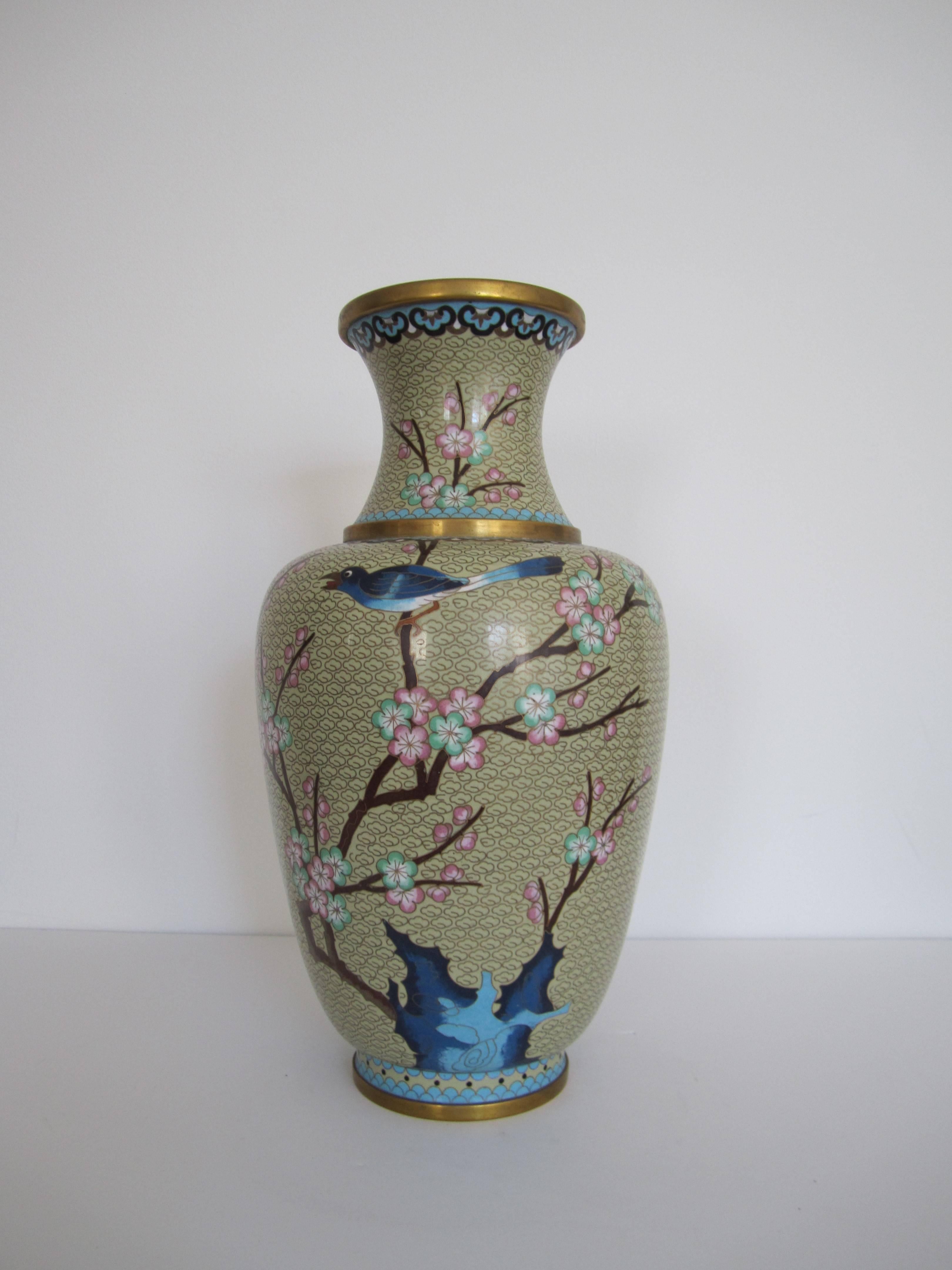 A beautiful large vintage Chinese Cloisonné vase, circa 1970s, depicting cherry blossoms and a bird perched on its branch. Colors include, blue, light blue, cream, brown, green, pink, black, etc. Measuring 15.5